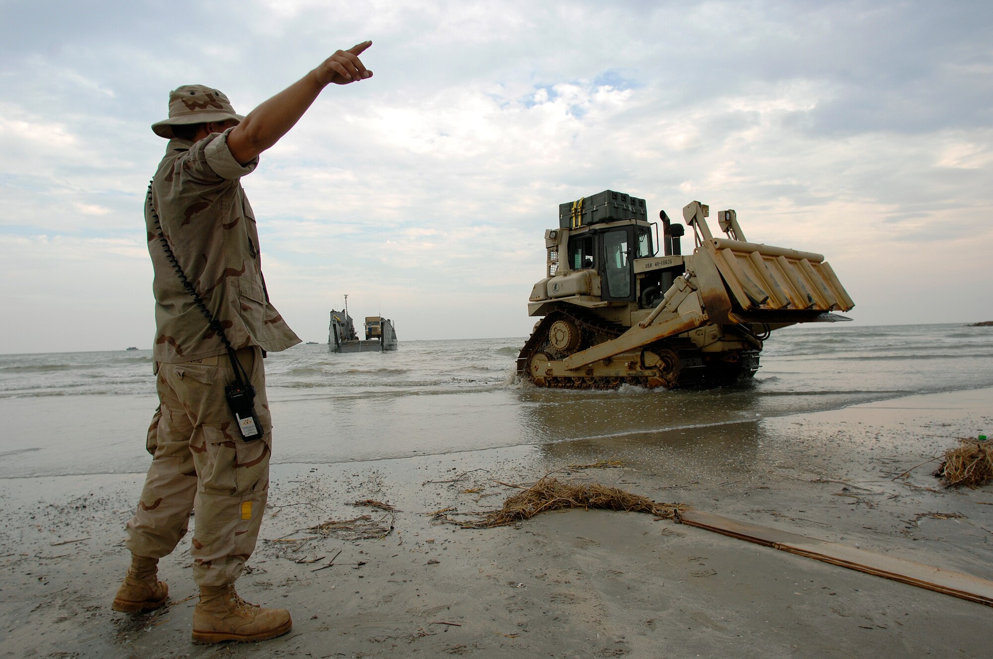 Seaman Gregory Newland directs a utility landing craft from the amphibious assault ship USS Nassau onto the beach near the port of Galveston, Texas to begin disaster relief efforts Sept. 18. The Nassau is anchored off Galveston to provide disaster response and aid to civil authorities as directed in the wake of Hurricane Ike. Seaman  Newland is assigned to Beachmaster Unit Two. (U.S. Air Force photo/Staff Sgt. Bennie J. Davis III)