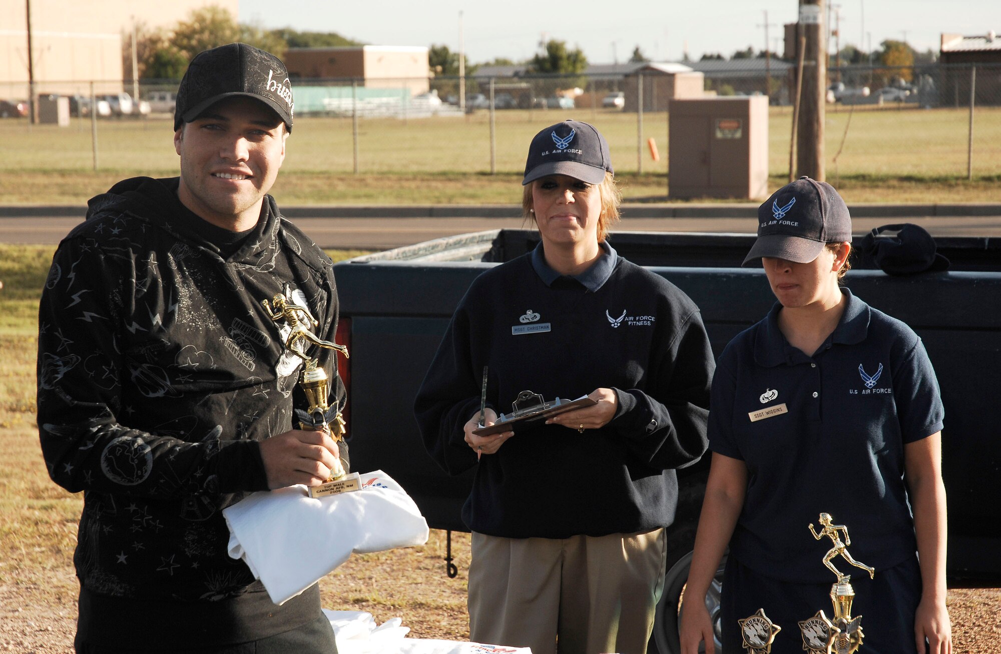 CANNON AIR FORCE BASE, N.M. -- Airman Jared Snell, 27th Special Operations Civil Engineer Squadron, won first place for the men's 100-meter dash with a time of 10.02 seconds Sept. 18. Master Sgt. Gina Christman and Staff Sgt. Helen Wiggins, 27th Special Operations Services Squadron, helped present the awards to the winners. (U.S. Air Force photo/Senior Airman Liliana Moreno)