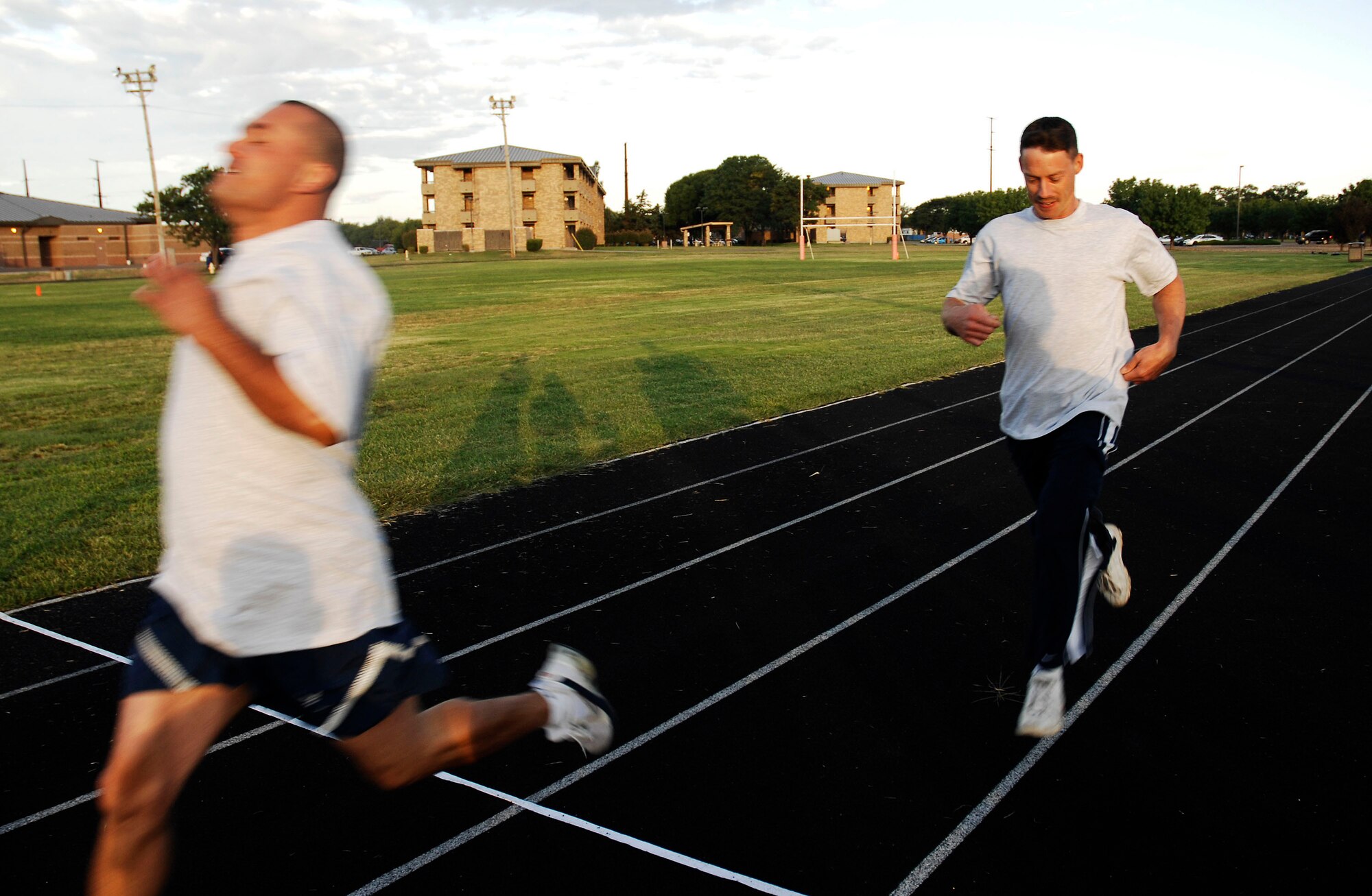 CANNON AIR FORCE BASE, N.M. -- Tech. Sgts. Dealous Fowler and Michael Amado, 27th Special Operations Equipment Maintenance Squadron, sprint across the finish line during a 100-meter dash Sept. 18. The run for the fastest male/female competition was hosted by the 27th Special Operations Services Squadron. (U.S. Air Force photo/Senior Airman Liliana Moreno)