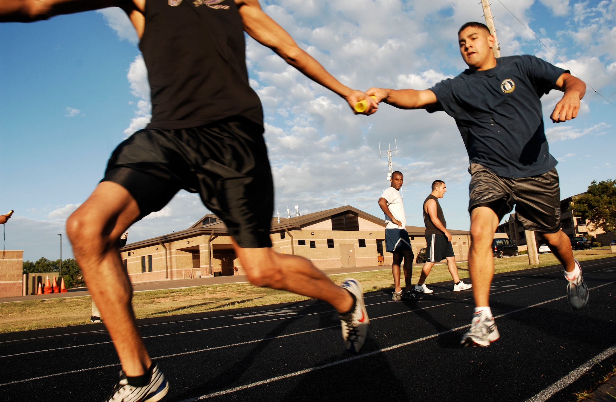 CANNON AIR FORCE BASE, N.M. -- Staff Sgt. Jonathan Coronado, 27th Special Operations Equipment Maintenance Squadron, passes the baton to his partner during a four-person relay run Sept. 18. The run for the fastest male/female competition was hosted by the 27th Special Operations Services Squadron. (U.S. Air Force photo/Airman 1st Class Evelyn Chavez)  