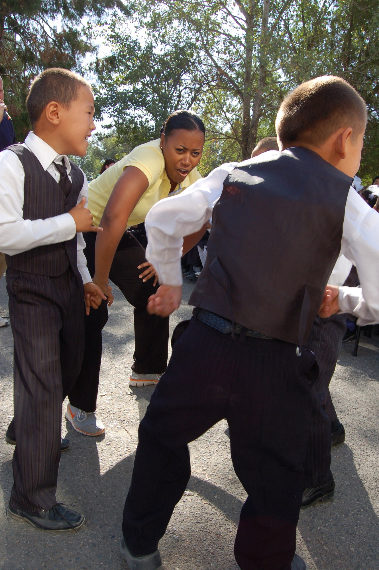 Master Sgt. Regina Coonrod sings and dances with two Kyrgyz boys during a Sept. 9 visit to an orphanage in Nizhanchuisk, Krygyzstan. The U.S. Air Force Central Band Yuma performed there during their eight-day tour where they played at six schools, villages and orphanages and four concerts on base. (U.S. Air Force photo/Senior Master Sgt. Patrick McCracken) 
