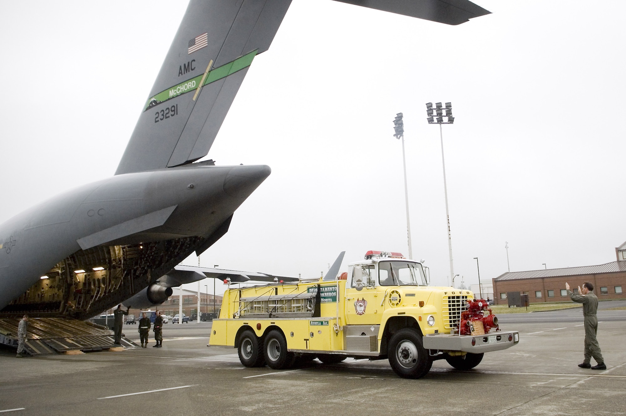 Loadmasters work together to load a firetruck onto a C-17 Globemaster III Sept. 19 at McChord Air Force Base, Wash. The firetruck and pallets of rescue equipment are headed to a remote village outside of Guadalajara, Mexico. Through the Denton Amendment, three local Washington nonprofit agencies worked with the 446th Airlift Wing for more than a year in order to transport the firetruck and cargo to Mexico. (U.S. Air Force photo/Abner Guzman) 
