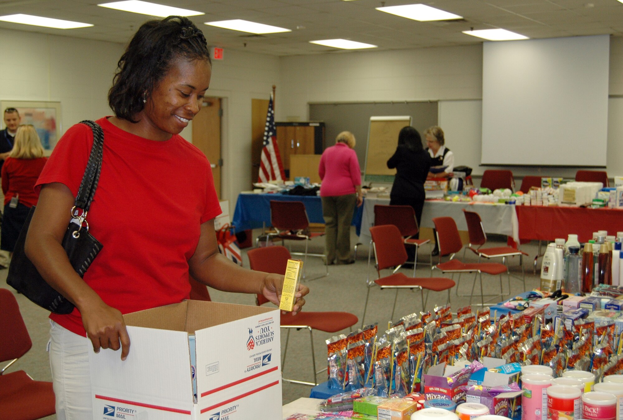 Alexis Thomas, the mother of Airman 1st Class Maurice Thomas Jr., deployed from the 94th Security Forces Squadron here, packs a care package with donated items to send to her son overseas. The Family Readiness center partnered with Cobb County to host a 'Family Care Package' day at the base Sept. 13. Several family members showed up to take advantage of creating a care package that the U.S. Post Office would ship at a $10 flat rate. (U.S. Air Force photo/Erin Tindell)