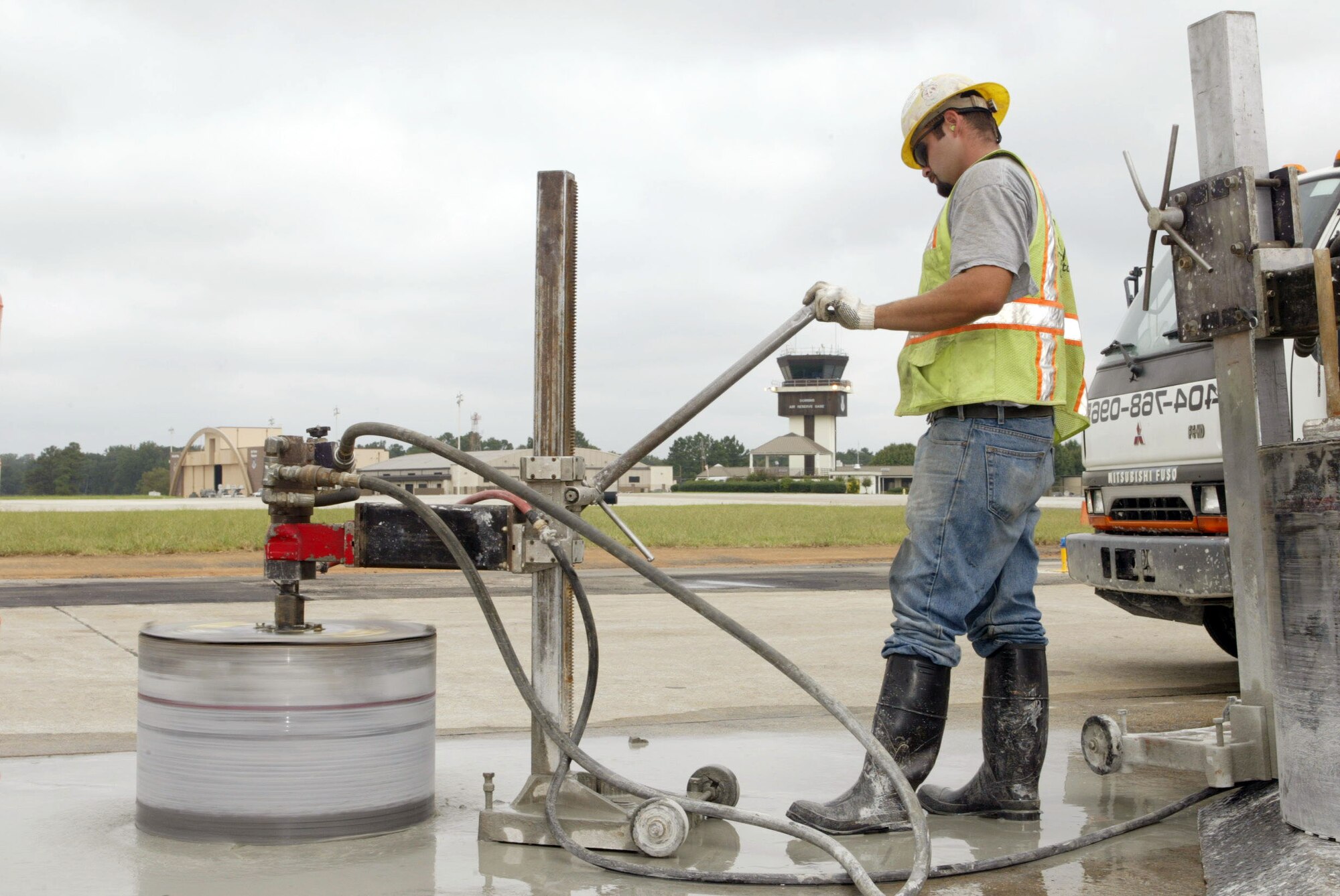 A construction crew member drills into the runway to remove a segment of concrete
required to replace aging runway lighting. The runway was closed Aug. 18 through
Sept. 19 during the renovation. (Air Force photo/Don Peek)