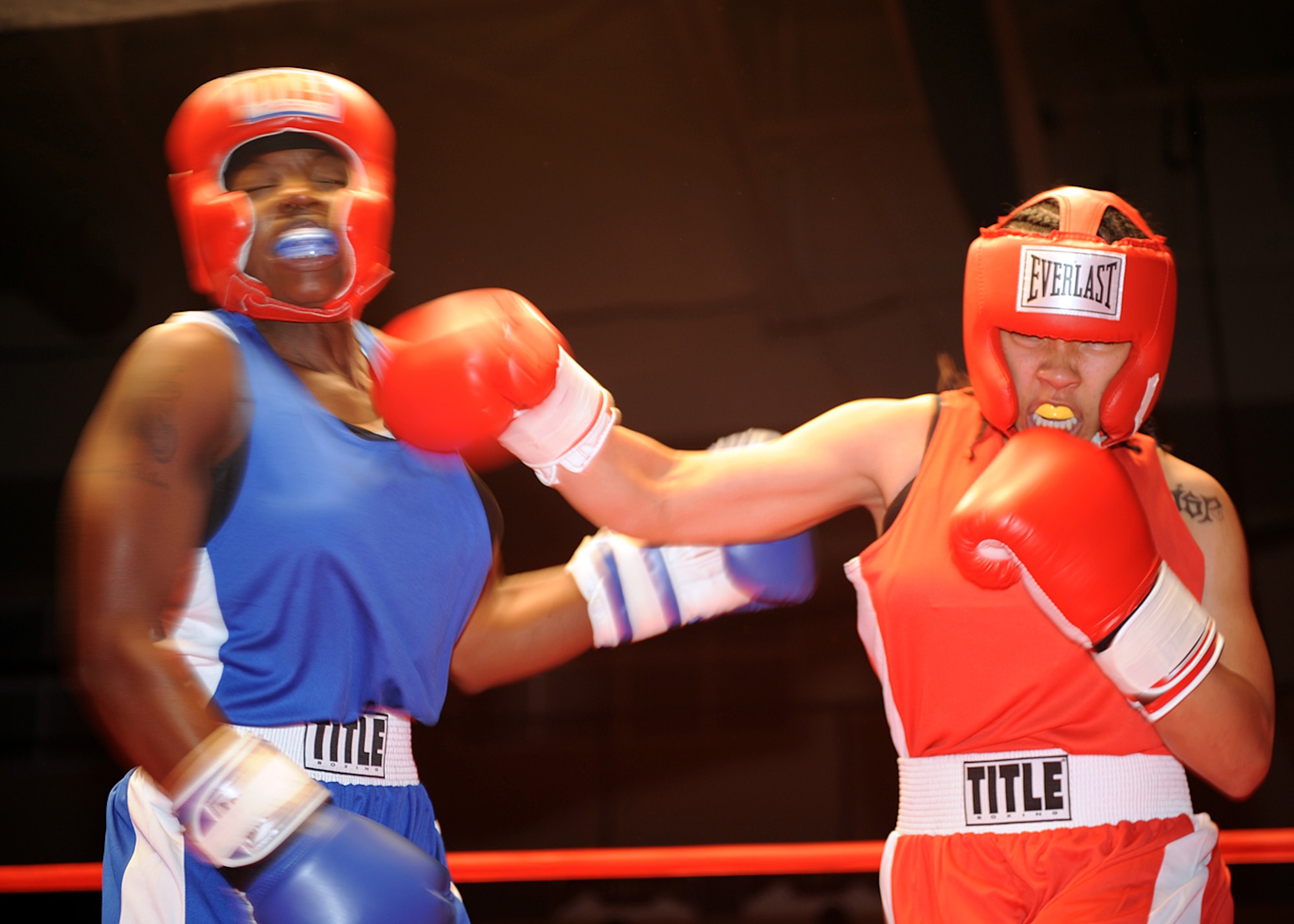 Senior Airman Lauren Moss, 49th Aero-Medical Squadron, lands a punch on Tech. Sgt. Genese Williams, 49th Materiel Maintenance Support Squadron, during their fight at the "Raptor Rumble 2," Sept. 12. Airman Moss and Sergeant Williams fought all three one minute rounds. (U.S Air force photo/ Airman 1st Class DeAndre Curtiss )