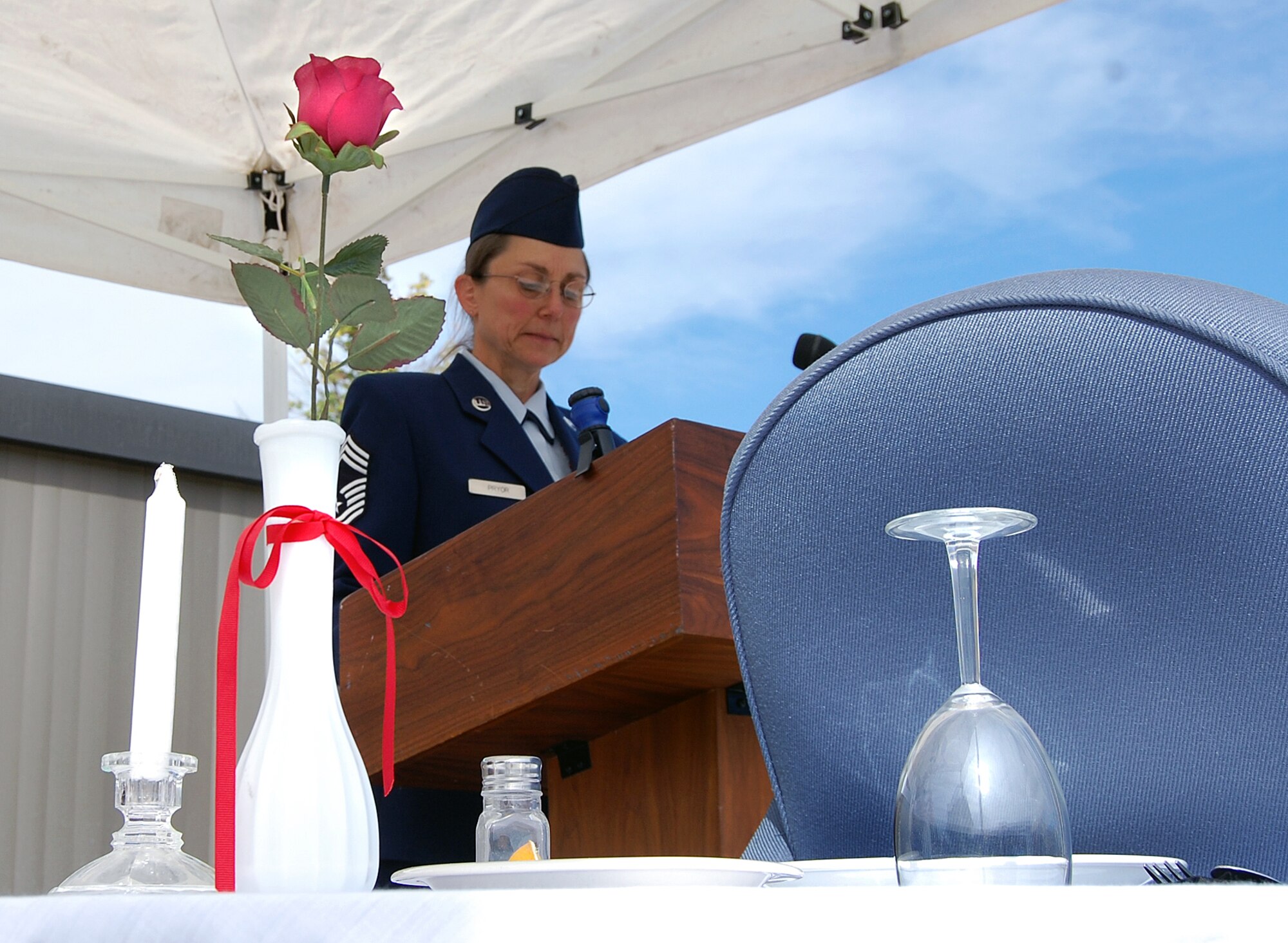 To commemorate National POW/MIA Recognition Day, Chief Master Sgt. Valerie Pryor reads some of the names of more than 10,000 prisoners of war or those missing in action since the Cold War during a vigil at ARPC on Sept. 18. Featured during the vigil is the missing man table, set symbolically for those still missing in action. (U.S. Air Force photo/Ellen Edwards)