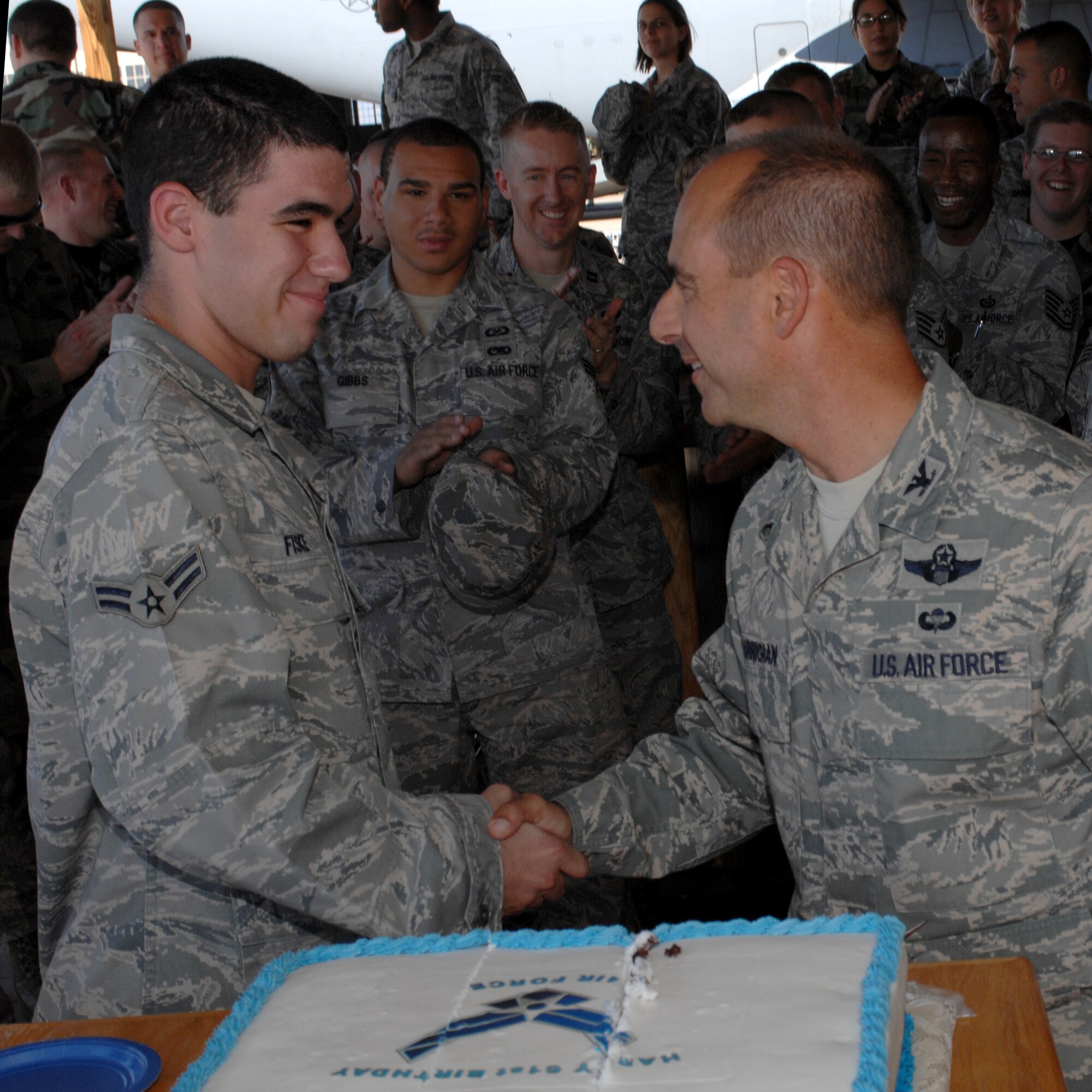Col. Jeff Harrigian, 49th Fighter Wing commander, shakes the hand of Airman 1st Class Joshua Fiske, 49th Operations Support Squadron, after cutting the birthday cake at the Air Force birthday celebration outside the 7th Fighter Squadron at Holloman Air Force Base, N.M., September 16. Airman Fiske was chosen to cut the cake with the colonel as he is the youngest member of the 49 OSS. The cake was in honor of the Air Force?s 61st Birthday. (U.S. Air Force photo/Airman Sondra M. Escutia)