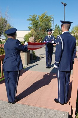 Airman 1st Class Bruce Rivera-Agurto and Staff Sgt. Neil Young prepare to fold the flag at a POW/MIA retreat ceremony at Medal of Honor park Sept. 17 as Senior Airman Robert Coleman looks on. (U.S. Air Force photo/Senior Airman Emerald Ralston)