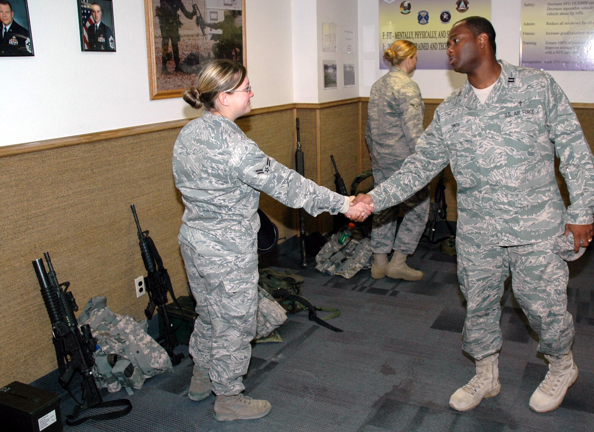 Chaplain (Capt.) Corwin Smith, 341st Missile Wing chaplain, shakes hands with Airman 1st Class Chelsea Moschell, 741st Misille Security Forces Squadron member, at guard mount in Building 500. (U.S. Air Force photo/Airman 1st Class Dillon White)