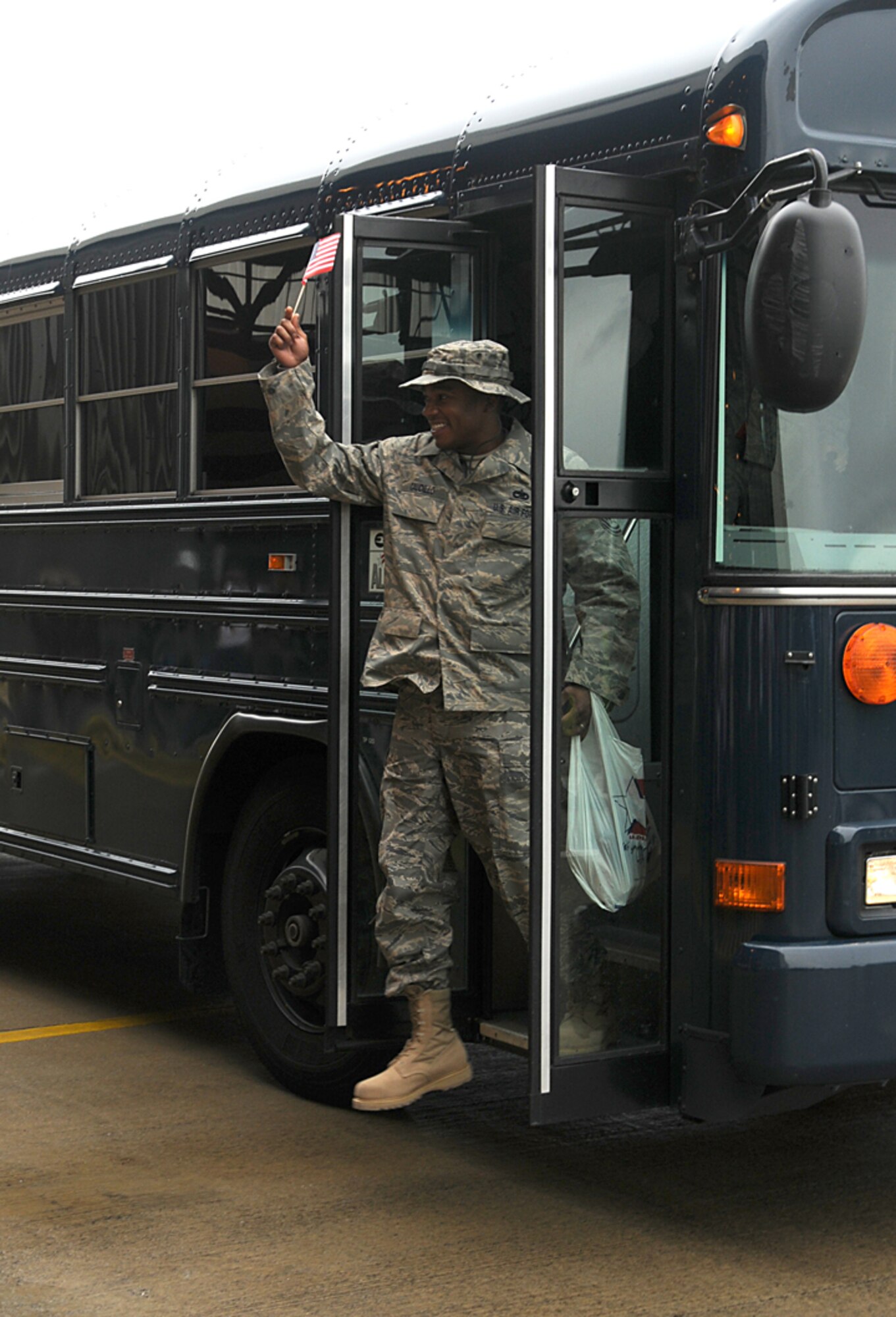 Tech. Sgt. Raymond Caudillo, 48th Aircraft Maintenance Squadron, waves a flag to fellow Airmen as he returns home to RAF Lakenheath, England Sept. 8. Sergeant Caudillo was one of more than 200 Airmen who returned home from deployments in support of Operations Enduring and Iraqi Freedom. (U.S. Air Force photo by Tech. Sgt. J. LaVoie)