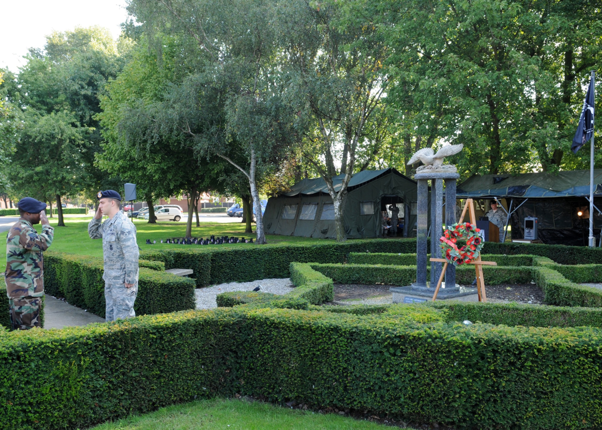 Staff Sergeant Newell Slagle, from the 100th Security Forces Squadron, reads names of military members either captured or missing in action during a 24-hour vigil at the Prisoner of War/Missing in Action memorial here Sept. 19, 2008. As Sergeant Slagle reads, Staff Sergeant Che Bain salutes Senior Airman Kieth Garrie, both from the 100th Security Forces Squadron, before relieving him of his guard duties. Each volunteer would read names for five minutes and then would replace the member standing guard at the memorial for an additional five minutes. (U.S. Air Force Photo by Staff Sergeant Jerry Fleshman)