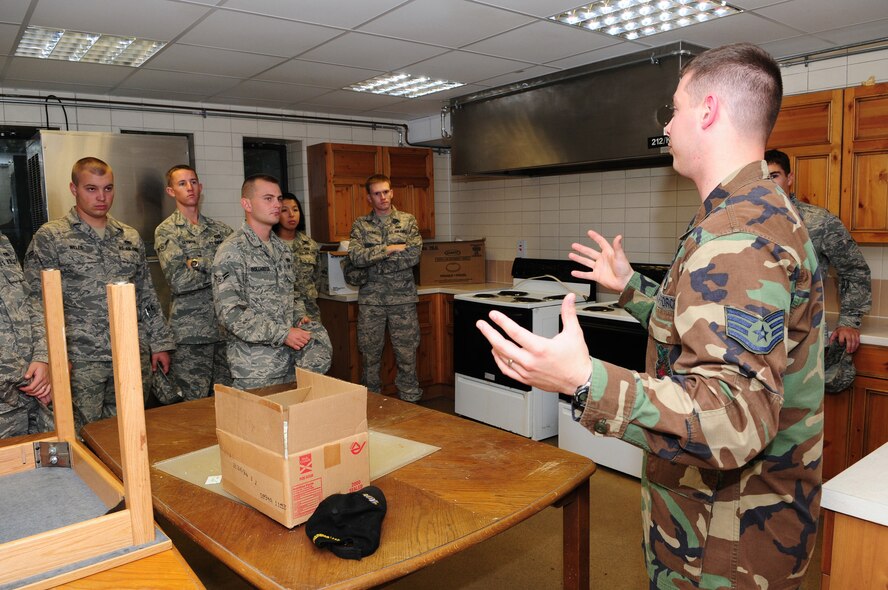 Staff Sgt. Guy Carriveau, right, 100th Civil Engineer Squadron Fire Prevention, talks with First Term Airmen Center students Sept. 15 in a disused dorm area. The fire prevention team have set up a "room of danger" in the dorm next to FTAC, both in a bedroom and a kitchen, to show different kinds of hazards and what is and isn't allowed. This will be a monthly event with FTAC students and discusses fire prevention in the household, dorms and the workplace. For more information on fire prevention, call DSN 238-4005. (U.S. Air Force photo by Karen Abeyasekere)