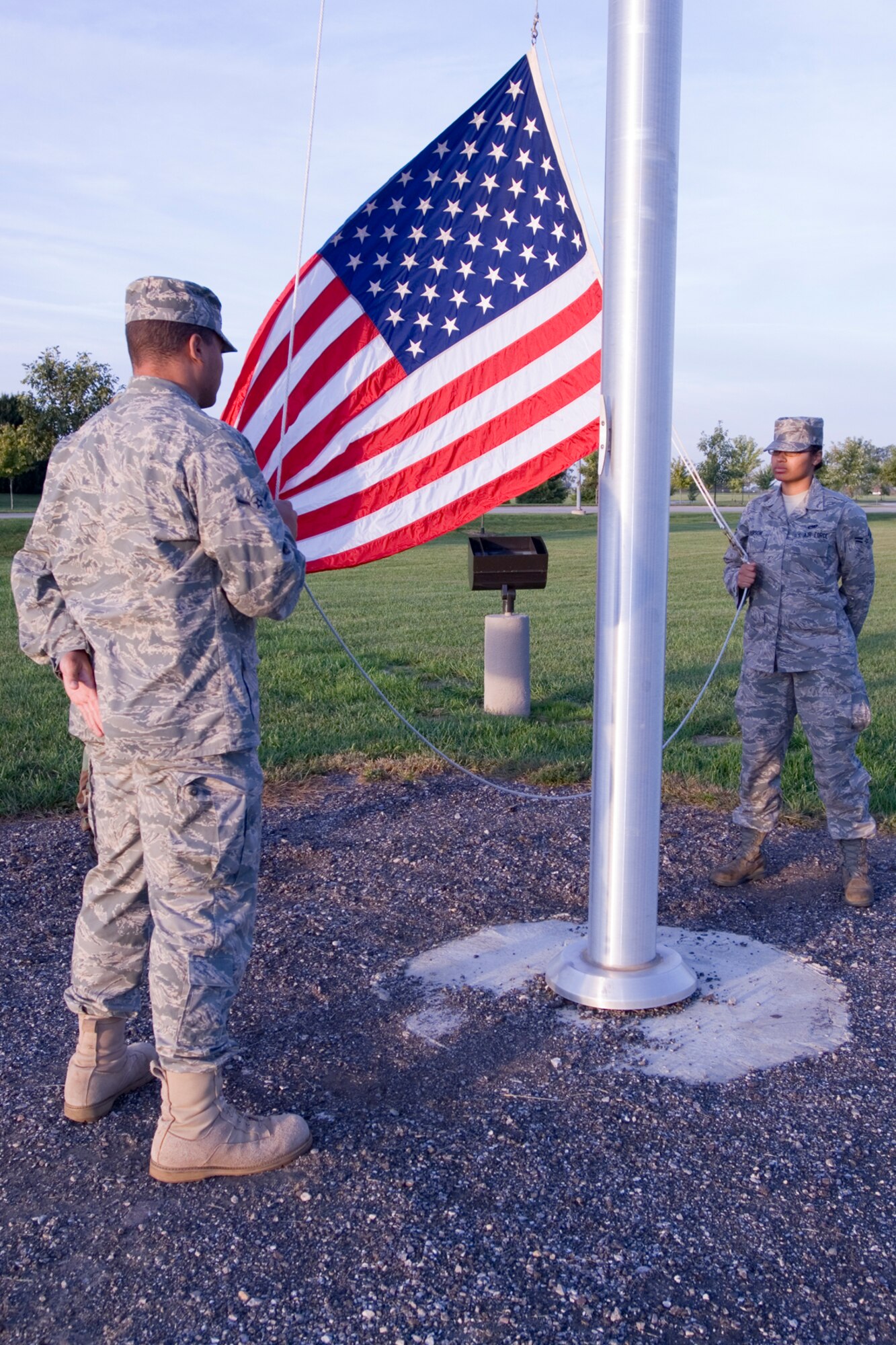 GRISSOM AIR RESERVE BASE, Ind., -- Airman Karl Person, 434th Maintenance Operations Flight, and his sister, Airman 1st Class Julia Person, 434th Aircraft Maintenance Squadron, prepare to raise the flag during a reveille ceremony. The Airmen are both part of the 434th Seasoning Flight. (U.S. Air Force photo/ Tech. Sgt. Doug Hays)