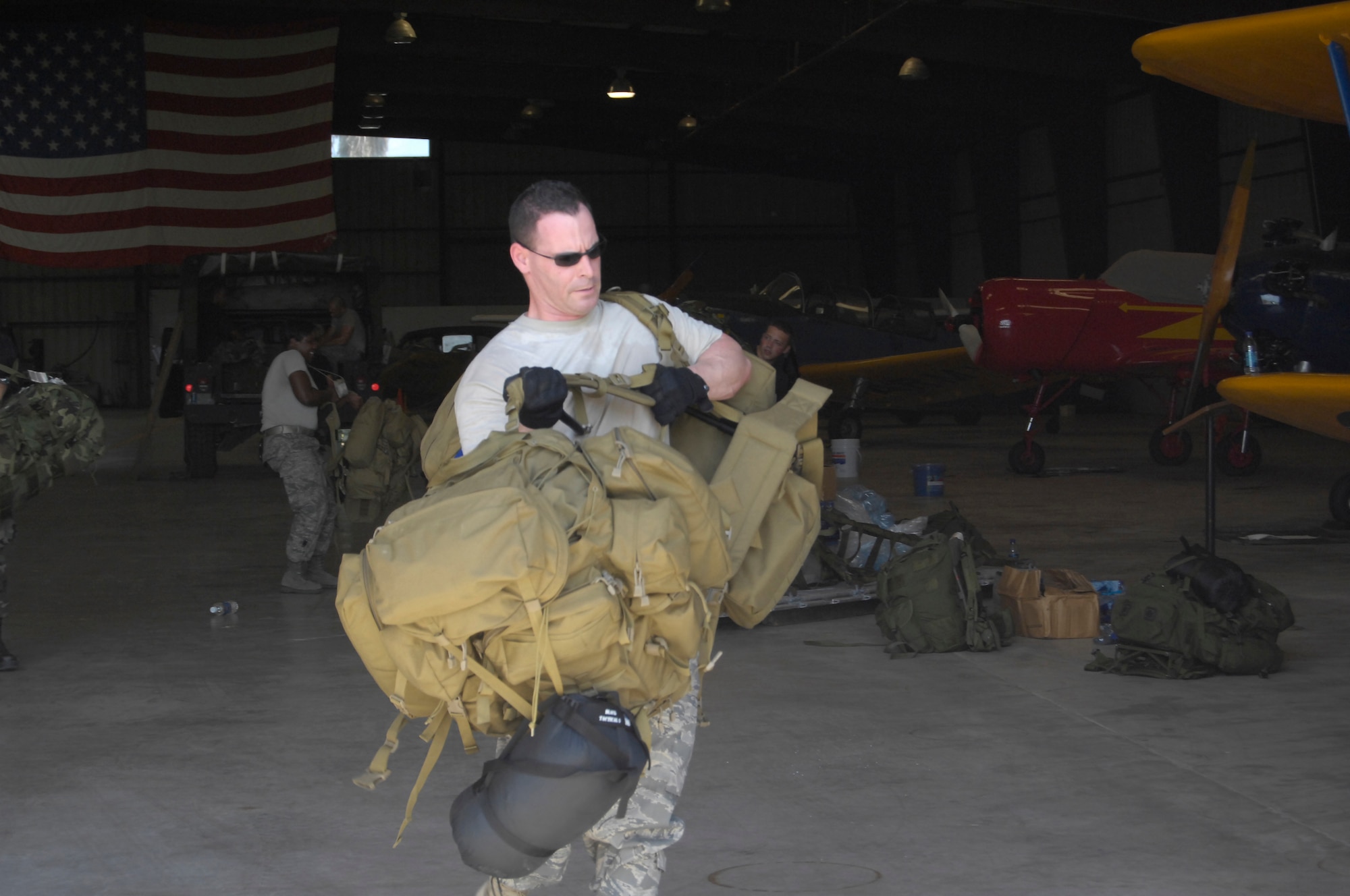 Capt. Charles Moniz, Aeromedical Evacuation Liaison Team member, carries a couple of rucksacks to be palletized before leaving the Mobile Aeromedical Staging Facility in Brownsville, Texas during Hurricane Ike relief efforts. (U.S. Air Force Photo by Airman 1st Clas Mindy Bloem)