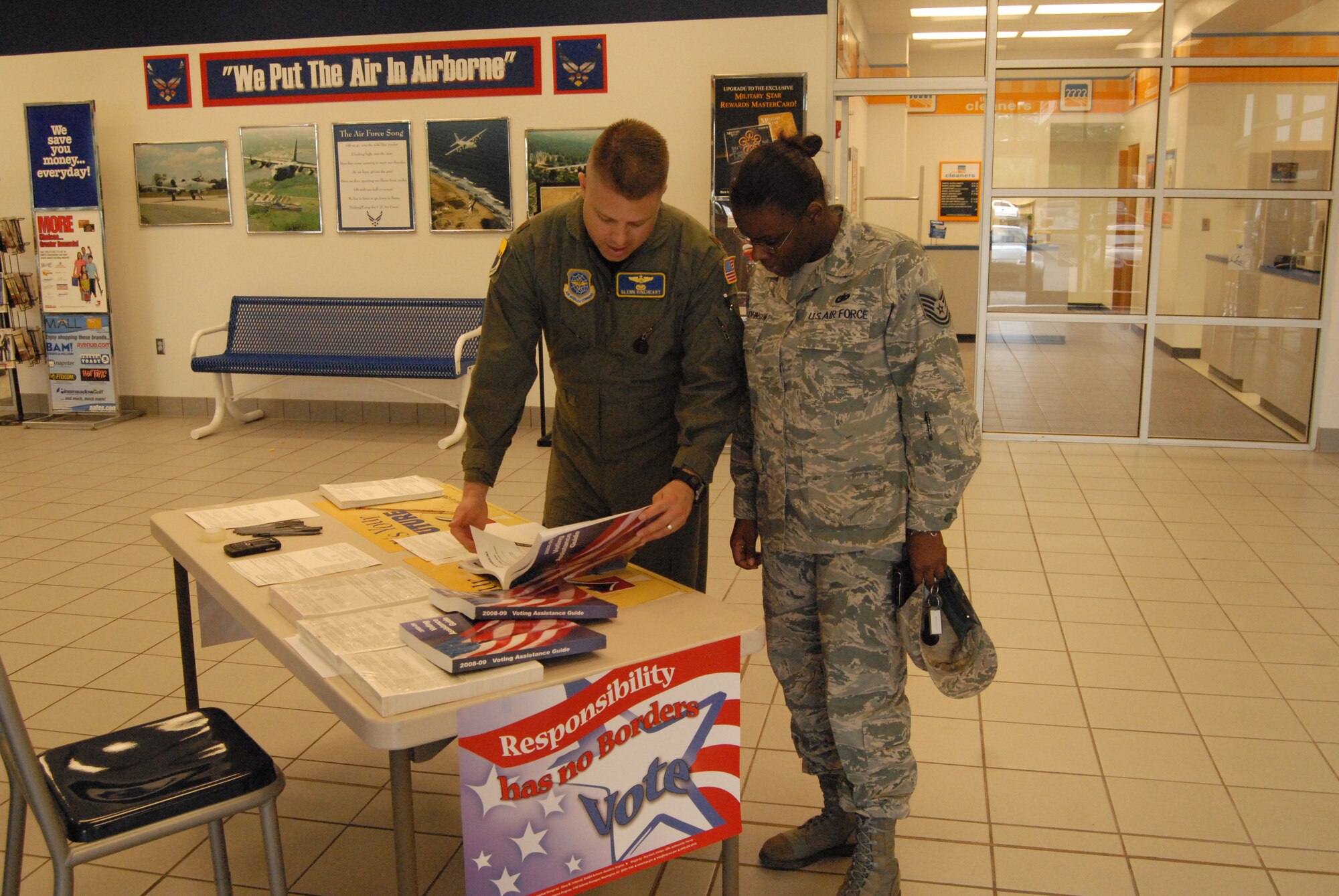 Maj. Glenn Rineheart, 43rd Airlift Wing, shows Tech. Sgt. Raniesa Gray-Johnson, 440th Mission Support Group, how to register for a South Carolina absentee ballot Sept. 9 at the Voter Registration table at the Shoppette. (U.S. Air Force Photo by Emily Smith)