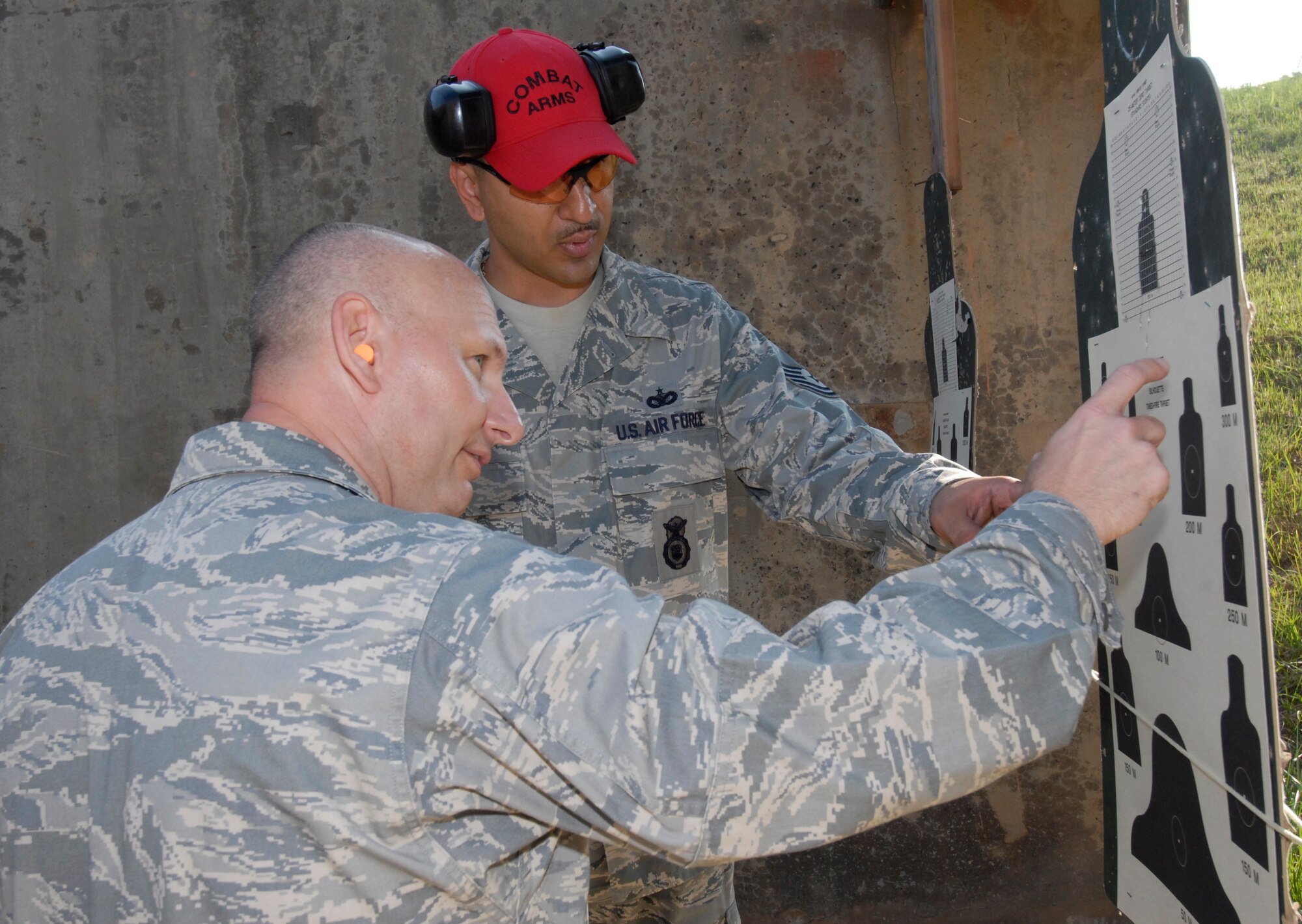 KUNSAN AIR BASE, Republic of Korea - Col. Charles "Hawk" Tedder, 8th Medical Group commander and Technical Sgt. Oscar Mendez, 8th Security Forces Squadron combat arms instructor analyzes targets after Colonel Tedder fired the M-4 carbine here Sept. 17. Wing  leadership spent the morning at the base firing range learning to shoot the M-4 carbine and qualifying on the tactical rifle qualification course. They also learned about the nomenclature of the M-4 and got a chance to practice shooting in different tactical positions. (U.S. Air Force photo by Senior Airman Dana Hill)