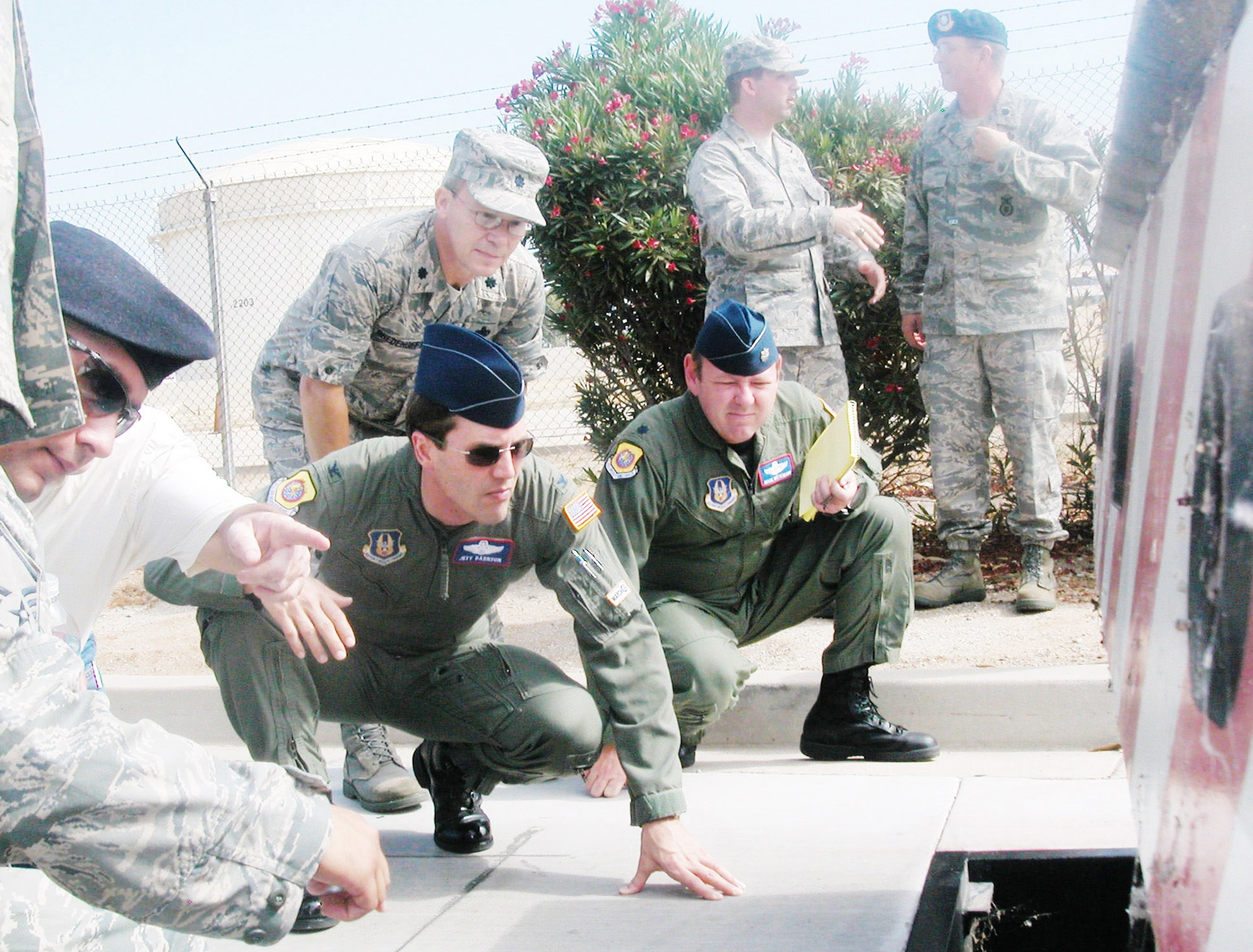Col. Jeffrey K. Barnson, (from left), 452nd Air Mobility Wing vice commander; Lt. Col. Mark Wittemann, chief of wing standardization/evaluation; and Lt. Col. Darrell Bredehoeft, 452nd Mission Support Group commander, take a closer look at the trap area underneath one of the barriers of the DCS501 system at March Air Reserve Base, Calif. (U.S. Air Force photo/Will Alexander)