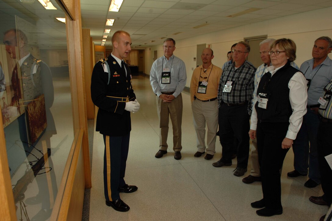 A Pentagon tour guide describes historical artifacts in a display case to participants in the Joint Civilian Orientation Conference as they tour the Pentagon. 