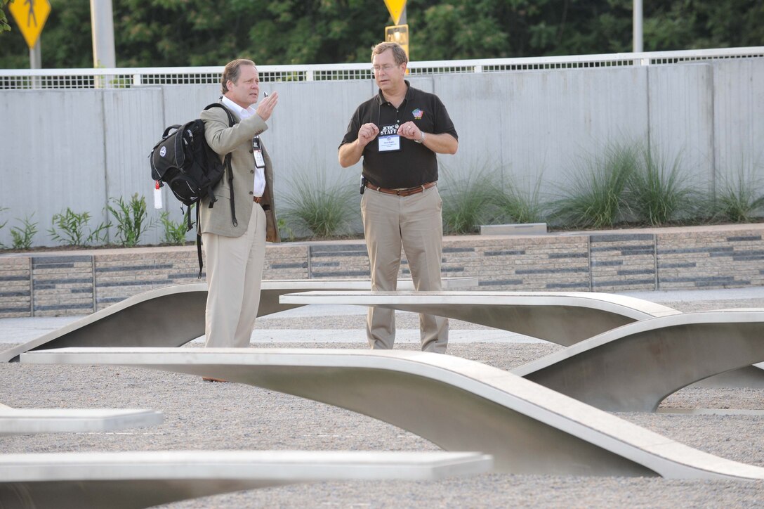 David Evans, a staff member in the Office of the Assistant Secretary of Defense for Public Affairs' Community Relations Office, right, explains the symbolism of the Pentagon Memorial to a participant in the Joint Civilian Orientation Conference. The JCOC group visited the memorial after a full day of Pentagon briefings and a tour. 