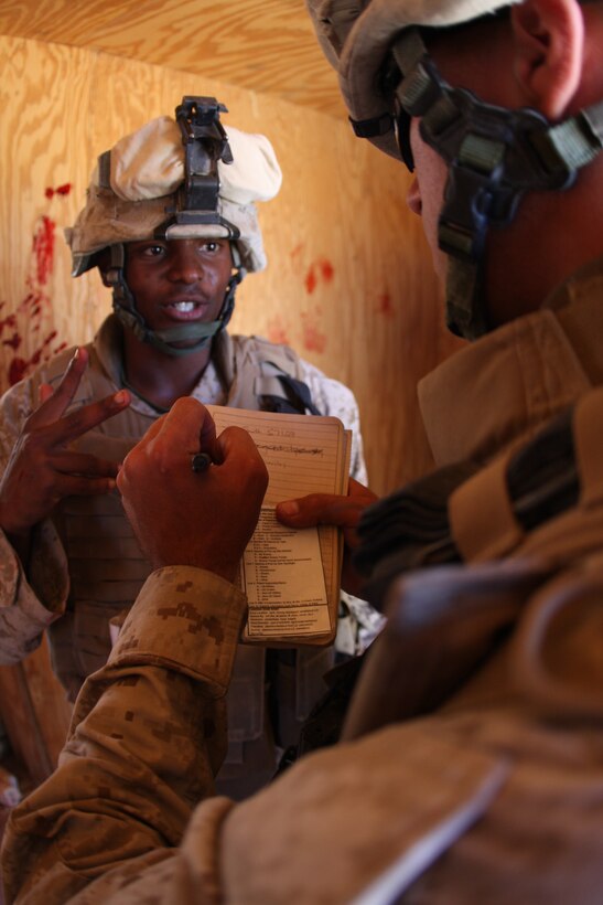 Seaman Tahlon Johnson, a hospital corpsman with Company K, 3rd Battalion, 8th Marine Regiment, relays information for a casualty evacuation during a first responder drill in a mock Afghan town at Range 215 as part of an Afghanistan-centered Mojave Viper at the Combat Center Sept. 20.