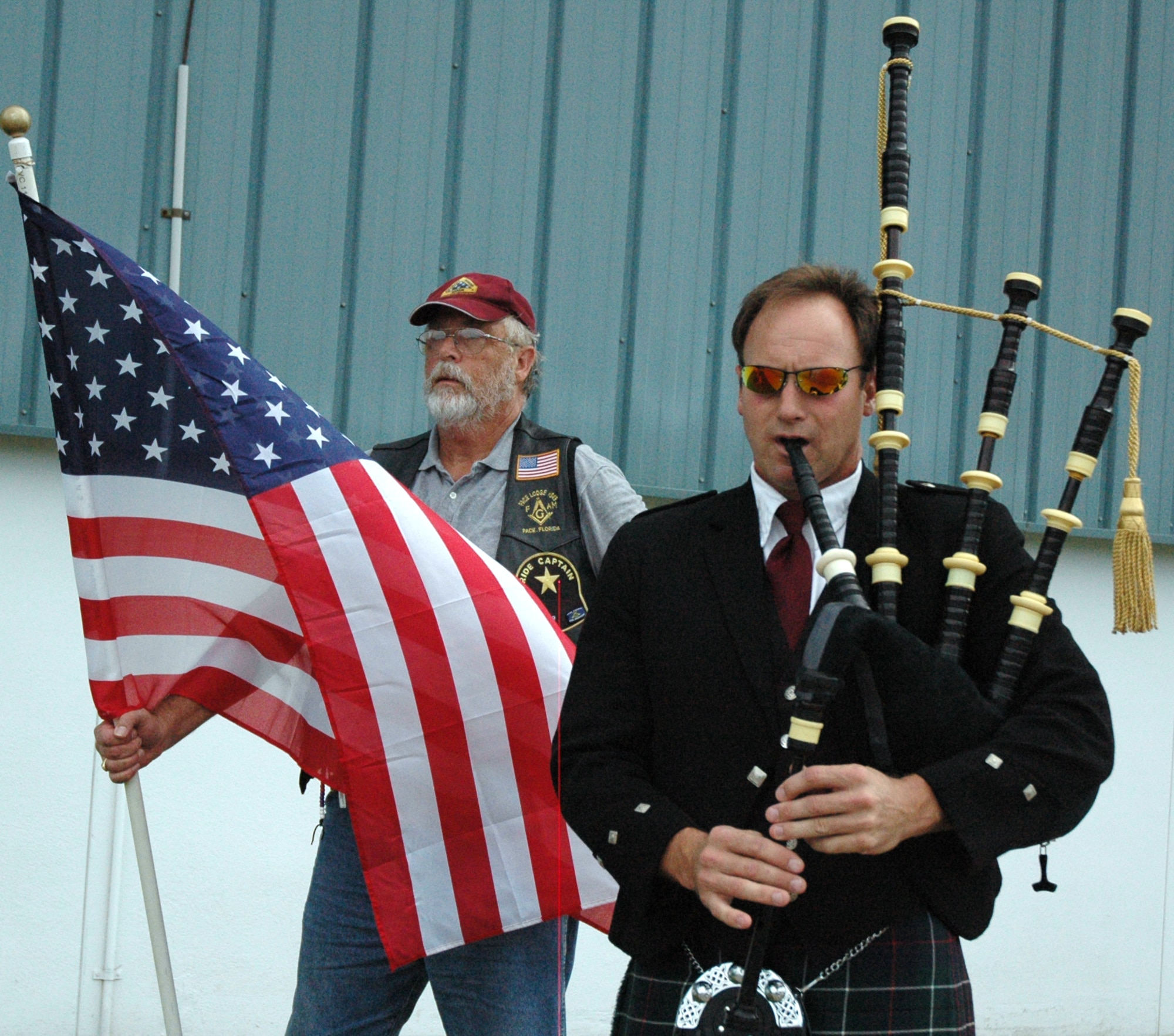 EGLIN AIR FORCE BASE, Fla. -- Master Sgt. Steven Bicknell, a Reservist at the 919th Maintenance Squadron at Duke Field, plays the bagpipe as Sam Wimberly from the Patriot Guard stands with the American flag at the beginning of the POW/MIA Ceremony Sept. 19 at the Air Force Armament Museum. This year's ceremony marked the seventh year Team Eglin has hosted the event to honor the sacrifices servicemembers have given and endured in the name of defending the United States of America. (U.S. Air Force photo/Staff Sgt. Stacia Zachary)