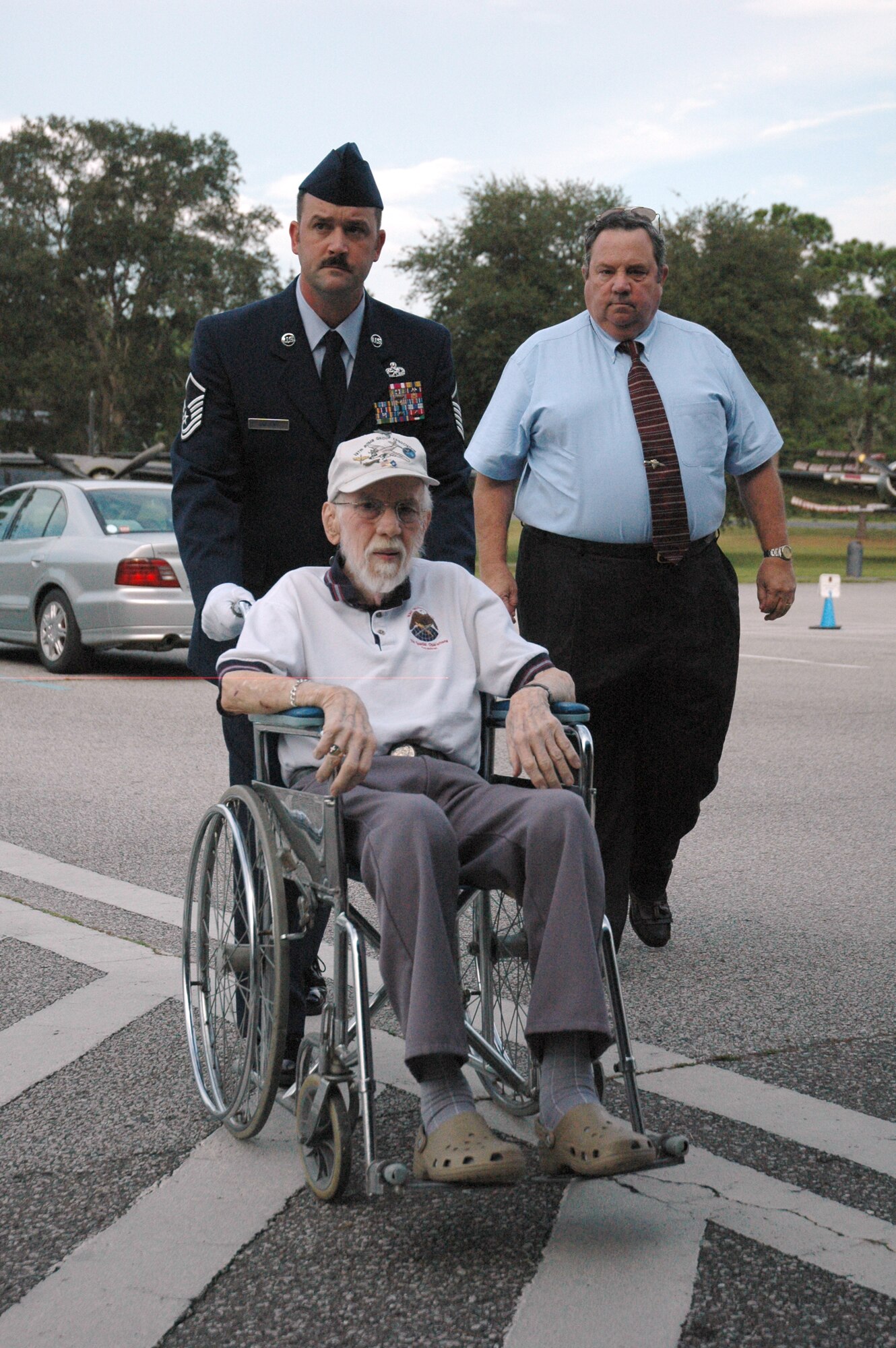 EGLIN AIR FORCE BASE, Fla. -- Veteran Michael Freeman (front), a member of the Army Air Corps and former prisoner of war during World War II, is escorted by his son, Michael, and Master Sgt. Craig Sargent, 46th Maintenance Squadron, as he enters the POW/MIA Ceremony Sept. 19 at the Air Force Armament Museum as an honored guest. This year's ceremony marked the seventh year Team Eglin hast hosted the event to honor the sacrifices servicemembers have given and endured in the name of defending the United States of America. (U.S. Air Force photo/Staff Sgt. Stacia Zachary)