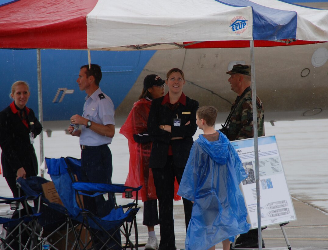 932nd Airlift Wing members work the display booth as light rain fell early Saturday morning, but the Airshow continued with many smiles.  As visitors come to the show this weekend, they will see the Joint Total Force Scott community coming together as one cohesive team. Personnel from the 375th Airlift Wing, the Reserves' 932nd Airlift Wing, the Air National Guard's 126th Air Refueling Wing, U.S. Transportation Command, Air Mobility Command, Military Surface Deployment and Distribution Command, along with Scott's other partners will all have a hand in making the show a great success.  (U.S. Air Force photo by Maj. Stan Paregien)
