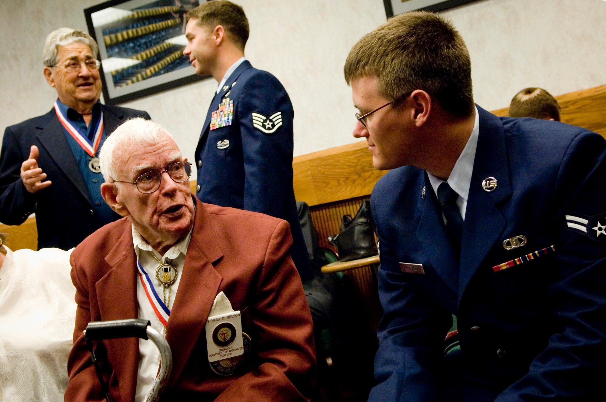 Airman 1st Class Peter Nodland, 62nd Operations Support Squadron, right, listens as Thomas C. Nelson, a former Prisoner of War tells his story during a meet and greet at the McChord club Sept 18. Nelson was captured during the Battle of Santa Cruz by the Japanese destroyer Yugumo in 1942 while serving in the Navy as an aviation radioman aboard the USS Enterprise CV-6 and interned in Japan for the remainder of the war. Presently, he is only of two surviving POW's interned in Japan who are also Pearl Harbor Survivors. (U.S. Air Force photo/Abner Guzman)
