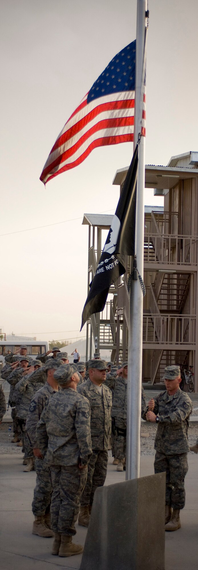 A flag detail comprised of Air Force Sergeants Association members lowers the POW/MIA flag during a recognition ceremony at Bagram Air Field, Afghanistan, Sept. 19. The POW/MIA ceremony was sponsored by the first AFSA chapter in Afghanistan (U.S. Air Force photo by Staff Sgt. Samuel Morse/RELEASED)