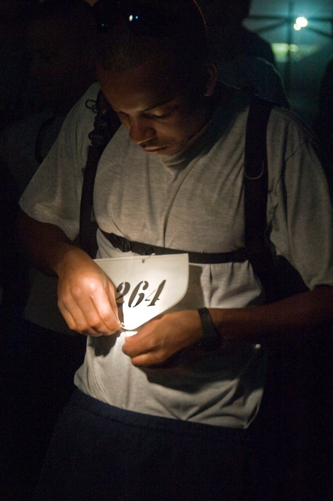 ALI BASE, Iraq -- Senior Airman Darrell Walters, 407th Expeditionary Communications Squadron, pins a bib number on his shirt. The Air Force Marathon in Iraq took place here Sept. 20, 2008. More than 70 Airmen, Soldiers, Sailors and civilians -- American and Romanian -- came out to run either the half or full marathon. Walters ran his first marathon and placed second overall. He is deployed from the 32nd Combat Communications Squadron at Tinker Air Force Base, Okla.  (U.S. Air Force photo/ Airman 1st Class Christopher Griffin)