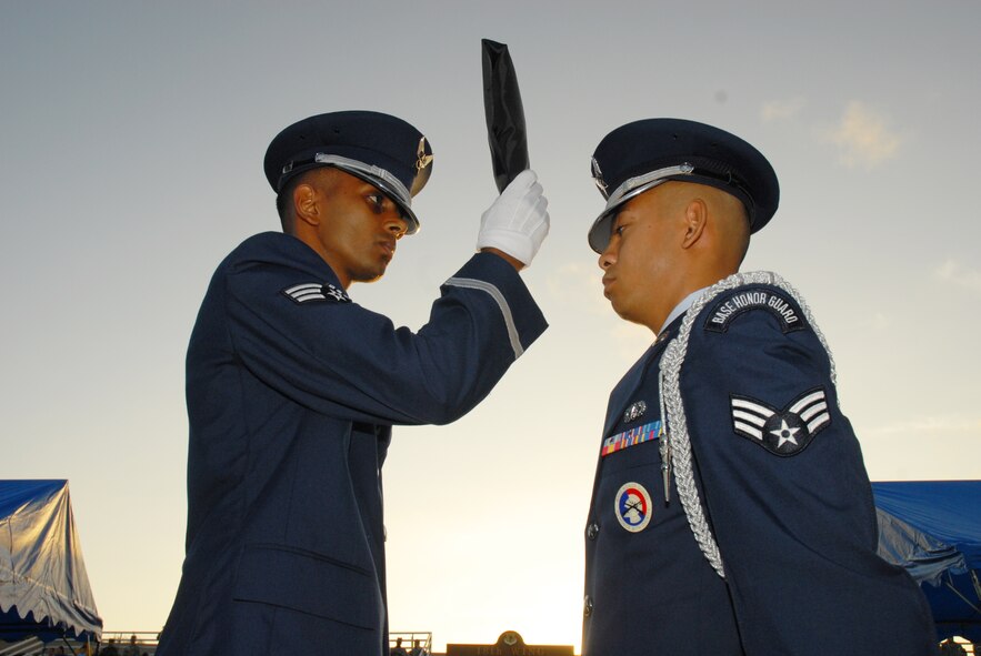 Senior Airman Aman Prasad passes the POW/MIA flag to Senior Airman Marlon Quitos of the Kadena Air Base Honor Guard during the base’s annual POW/MIA Memorial Ceremony Sept. 19, 2008. Kadena Air Base hosts a remembrance ceremony each year in honor of all POW/MIA service members past and present. (U.S. Air Force photo/Airman 1st Class Chad Warren)