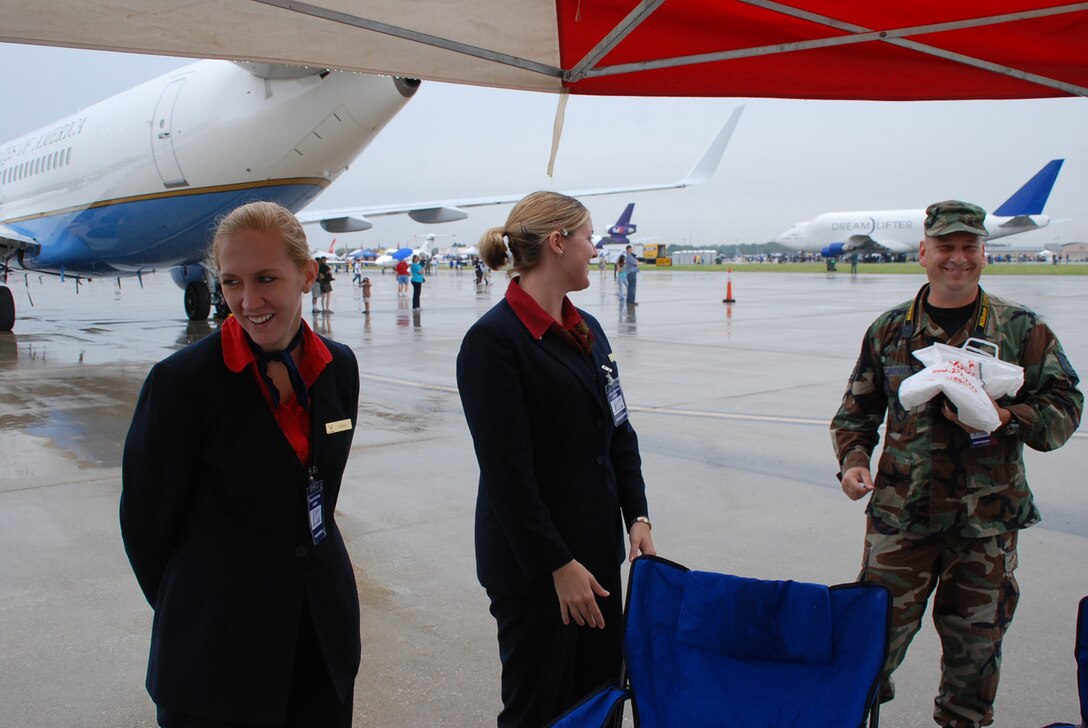 932nd Airlift Wing members share a moment during the Scott Air Force Base Airshow 2008 as they helped man an information booth between the C-40C (left) and a C-9C, which are both used for distinguished visitor missions.  (U.S. Air Force photo by Maj. Stan Paregien)