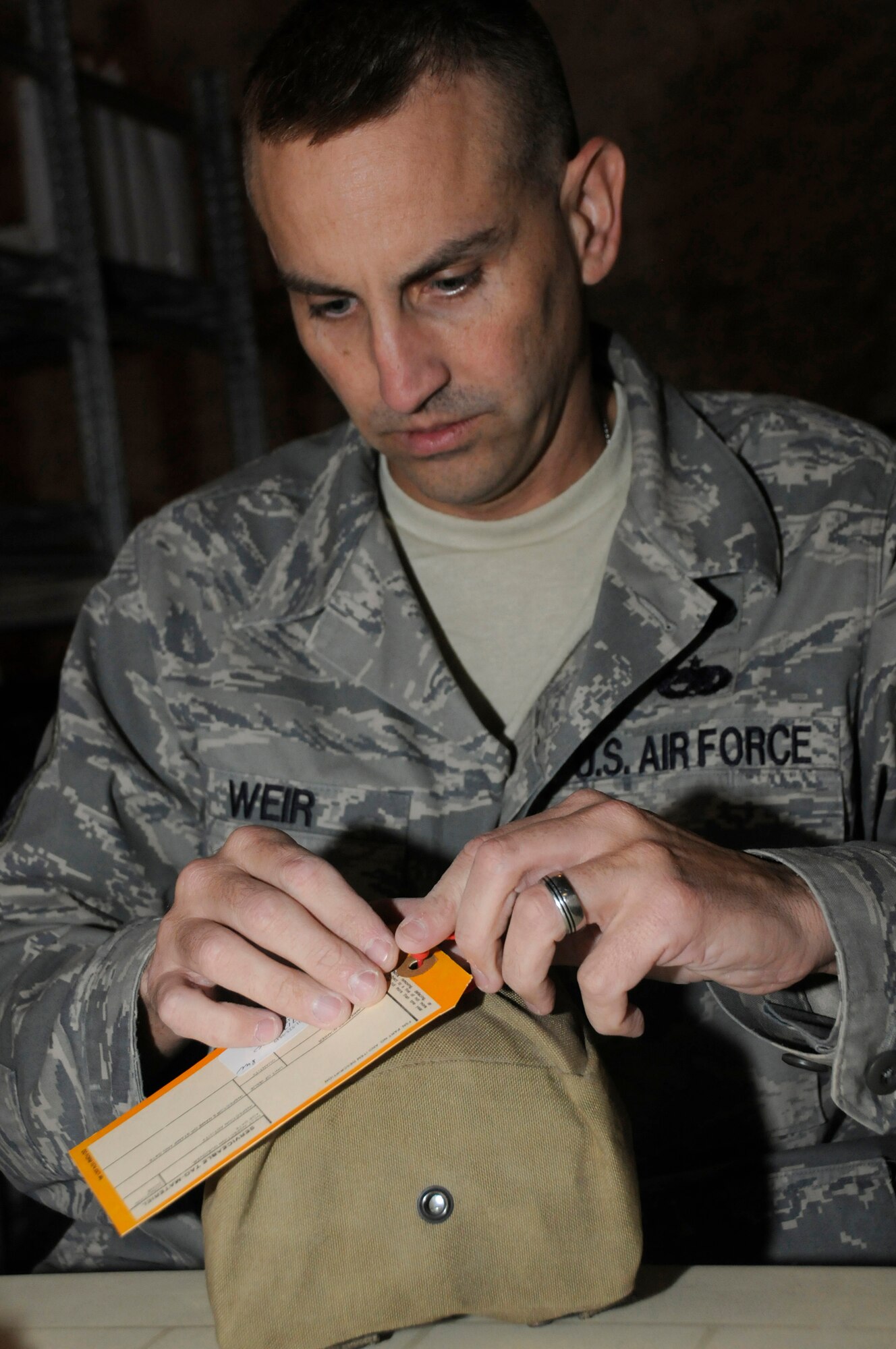 Master Sgt. Robert Weis, contracting officer assigned to the 379th Expeditionary Contracting Squadron, attaches a serviceable tag to an individual first aid kit Sept. 19, 2008, at an undisclosed air base in Southwest Asia. Once a week, volunteers recertify about 1,200 IFAKs to make sure the items inside are current so they can be used in the U.S. Central Command area of responsibility. Sergeant Weir, a native of Los Angeles, Calif., is deployed from Mountain Home Air Force Base, Idaho, supporting Operations Iraqi Freedom, Enduring Freedom and Joint Task Force-Horn of Africa. (U.S. Air Force photo by Staff Sgt. Darnell T. Cannady/Released)