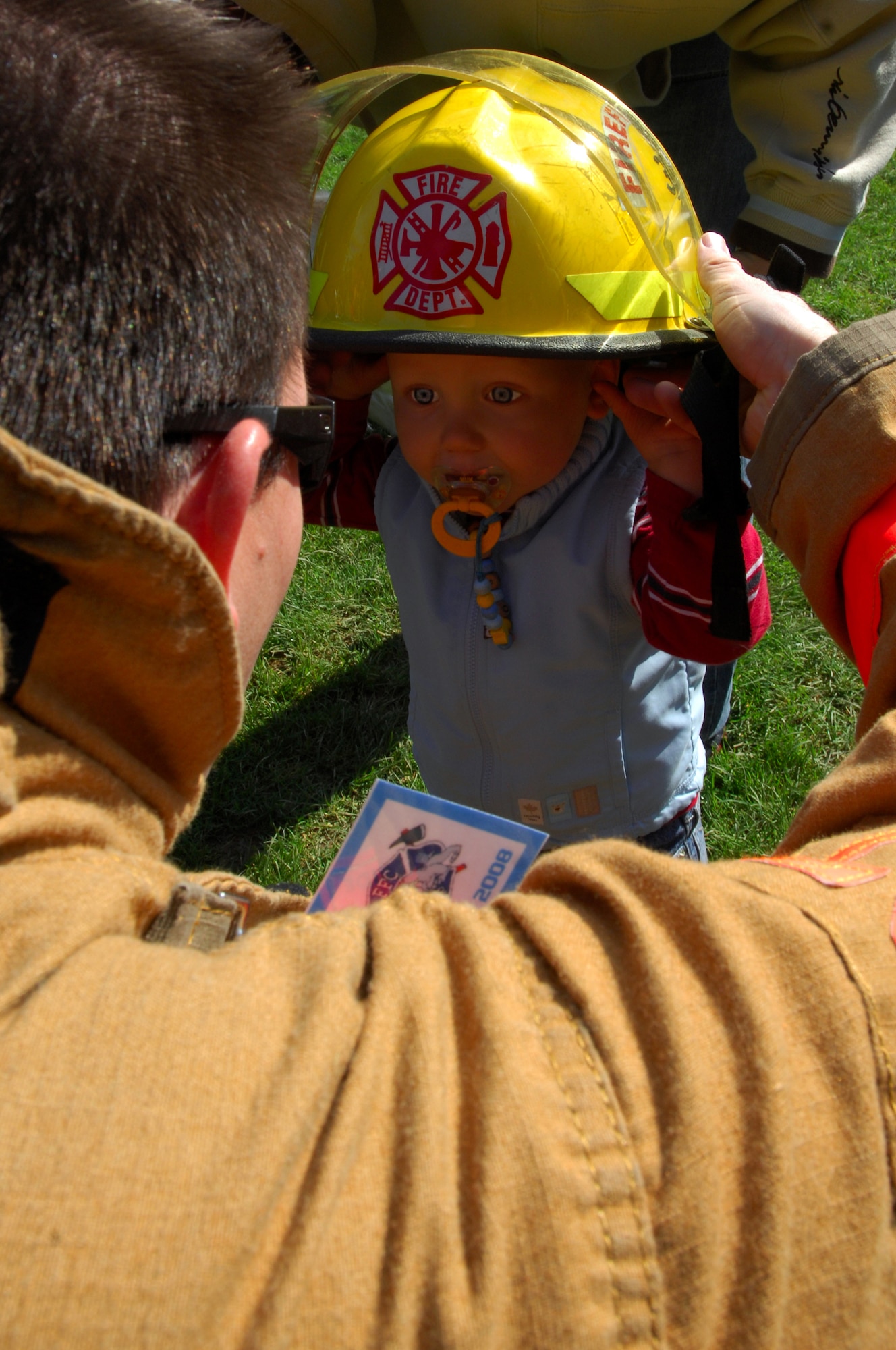 United States Air Force Staff Sgt. Jayson Adcock, 835th Civil Engineer Squadron Fire Department, lets Jason Blas?, son of Mike Blas?, also with the 835th CES Fire Department, try on his hat during the Firefighter Challenge 2008, Buchenbeuren, Germany, Sept. 14, 2008. Firefighters from over 40 different stations came together to compete in fire protection scenarios during the challenge. (U.S. Air Force photo Airman 1st Class Kenny Holston)(Released)*