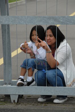 MISAWA AIR BASE, Japan -- Donna Aballa and her daughter, Ilia, watch as her husband Tech. Sgt. Albert Abella, 35th Maintenance Squadron, boards a plane Sept. 21, 2008.  Sergeant Aballa and members of the 14th Fighter Squadron and the 35th MXS are deploying to support the Global War on Terrorism.  (U.S. Air Force photo by Senior Airman Laura R. McFarlane) 