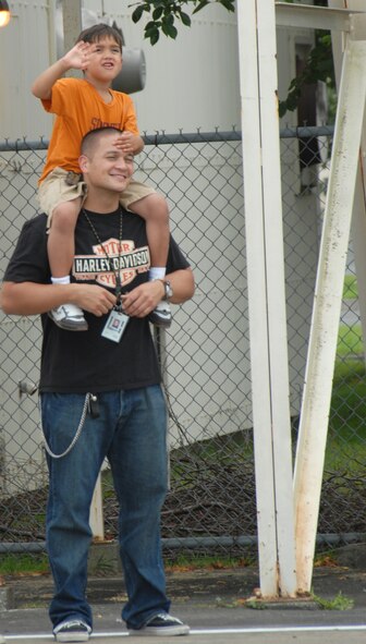 MISAWA AIR BASE, Japan -- Tech. Sgt. William Zimmermann, 35th Maintenance Squadron, and his five year old son, Kanoa, wave goodbye to spouse and mother Tech. Sgt. Donna Zimmermann, 14th Fighter Squadron Sept. 21, 2008.  Members of the 14th FS depart for a four month rotation.   (U.S. Air Force photo by Senior Airman Laura R. McFarlane) 