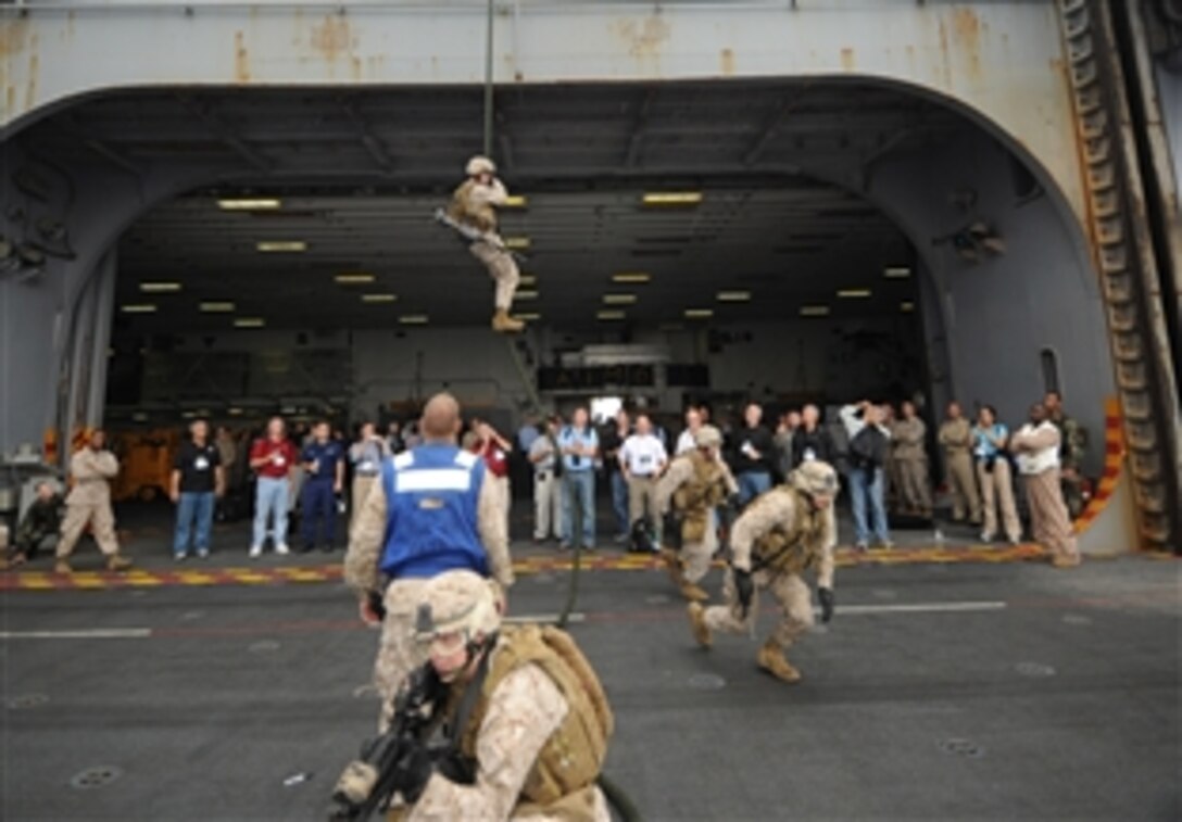 Marines from the 26th Marine Expeditionary Unit aboard USS Iwo Jima demonstrate a fast-rope exercise for participants in the Joint Civilian Orientation Conference who visited the ship Sept. 21, 2008. 