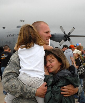 NIAGARA FALLS AIR RESERVE STATION, N.Y. -- Tech. Sgt. Vincent Gustafson, a pavements and equipment operator for the 914th Civil Engineering Squadron gets a reassuring hug from his wife and daughter that it's good to be home.  Gustafson was among 17 Air Force Reservists who recently arrived home from Bagram Air Base, Afghanistan.  These reservists  were deployed for approximately six months.  The group, part of an operation and maintenance team, were responsible for building and renovating facilities for the Army and other forward operating locations.  (U.S. Air Force photo/Master Sgt. Peter Borys)