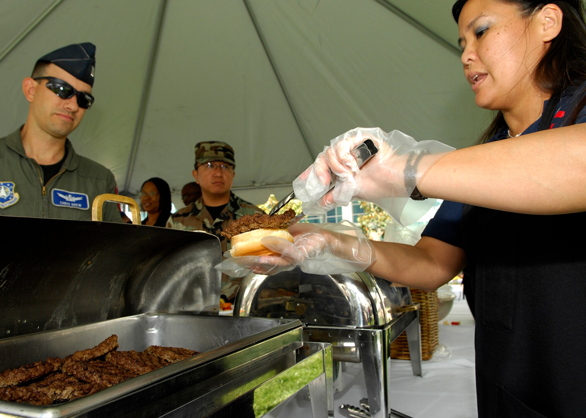 Christina Kobayashi, a facility member at the Child Development Center and 61st Services Squadron, help serve hamburgers to Los Angeles Air Force Base members at the Air Force birthday celebration in the Schriever Space Complex courtyard, Sep. 18. (Photos by Stephen Schester)