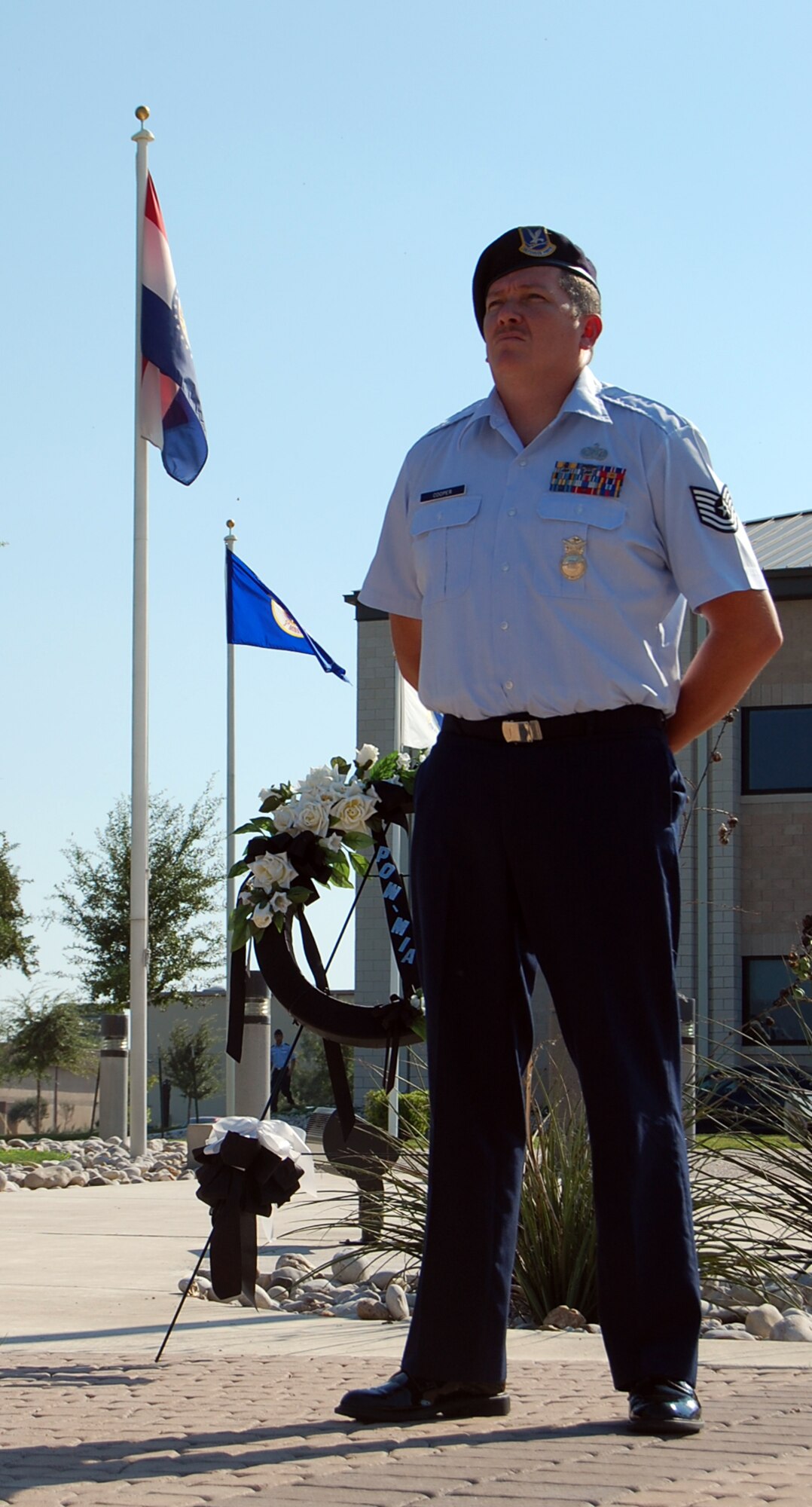 LAUGHLIN AIR FORCE BASE, Texas—Tech. Sgt. Thomas Cooper, 47th Security Forces Squadron, stands in silent vigil over a display honoring America's Prisoners of War and Missing in Action Sept. 19 at Laughlin AFB, Texas. Laughlin Airmen stood guard at the base flagpole in 30-minute shifts from 5 a.m. to 5 p.m. in observation of National POW/MIA Remembrance Day, held the third Friday in September. Sgt. Cooper had the final shift guarding the flag before it was retired during a special retreat ceremony.  (U.S. Air Force photo by 1st Lt. Courtney Kippenberger)