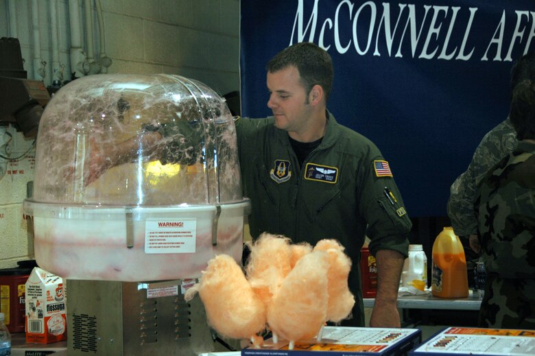 Staff Sgt. Jacob Cross reaches into a cotton candy machine during the 931st Air Refueling Group Family Day Picnic on Sept. 14.  Sergeant Cross, a KC-135 boom operator assigned the 18th Air Refueling Squadron, was one of the many 931st Airmen who volunteered to help during the picnic. (U.S. Air Force photo/Senior Airman Connor Burkhard)