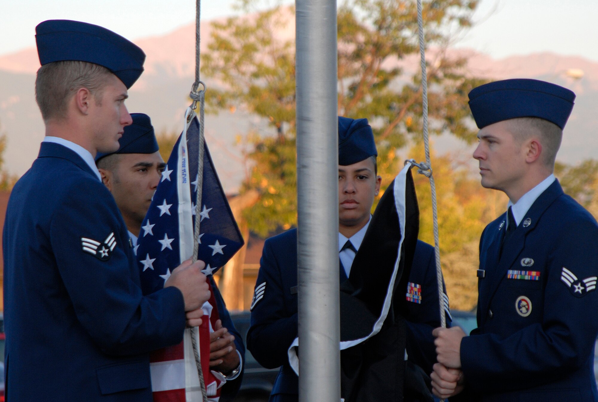 Airmen assigned to Peterson Air Force Base prepare to raise the United States flag and the POW/MIA flag at the base's museum in Colorado. The event was used as a forum to inform personnel about POW/MIA Remembrance Week on the base, which ran Sept. 15-19. POW/MIA week allowed members of the installation to remember those held prisoner of war and those missing in action during times of conflict. (U.S. Air Force photo/Craig Denton)
