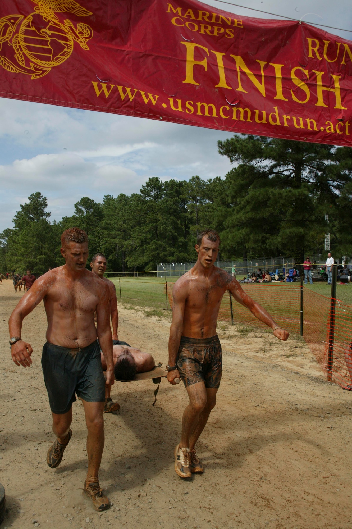 Eastover, S.C.-- Senior Master Sgt. Jason Hines (left), Senior Airman Trevor Brown (right) and Tech. Sgt. Scott Ackeret (back), members of the Shaw Air Force Base Explosive Ordnance Disposal flight, carry teammate, Senior Airman Michael Pasley, in a litter across the finish line of the 15th Annual U.S. Marine Corps Ultimate Challenge Mud Run at the USMC Reserve Center Sept. 20. The team ran the 4.2 mile challenge in 50 minutes and 12 seconds, placing 101st out of approximately 1,200 teams and 9th out of the 53 military teams. (U.S. Air Force photo/Staff Sgt. Holly Brown)