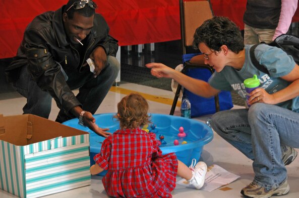 Senior Master Sgt. Sheila Croninger asks her 1-year-old daughter, Josie, to redeem the rubber duck she picked for a prize with Staff Sgt. Michael Sloan at the 931st Air Refueling Group Family Day Picnic on Sept. 14.  Sergeant Sloan was one of the many Airmen who volunteered to help make the picnic enjoyable for children.  He and Sergeant Croninger are assigned to the 931st Civil Engineer Squadron. (U.S. Air Force photo/Senior Airman Connor Burkhard)
