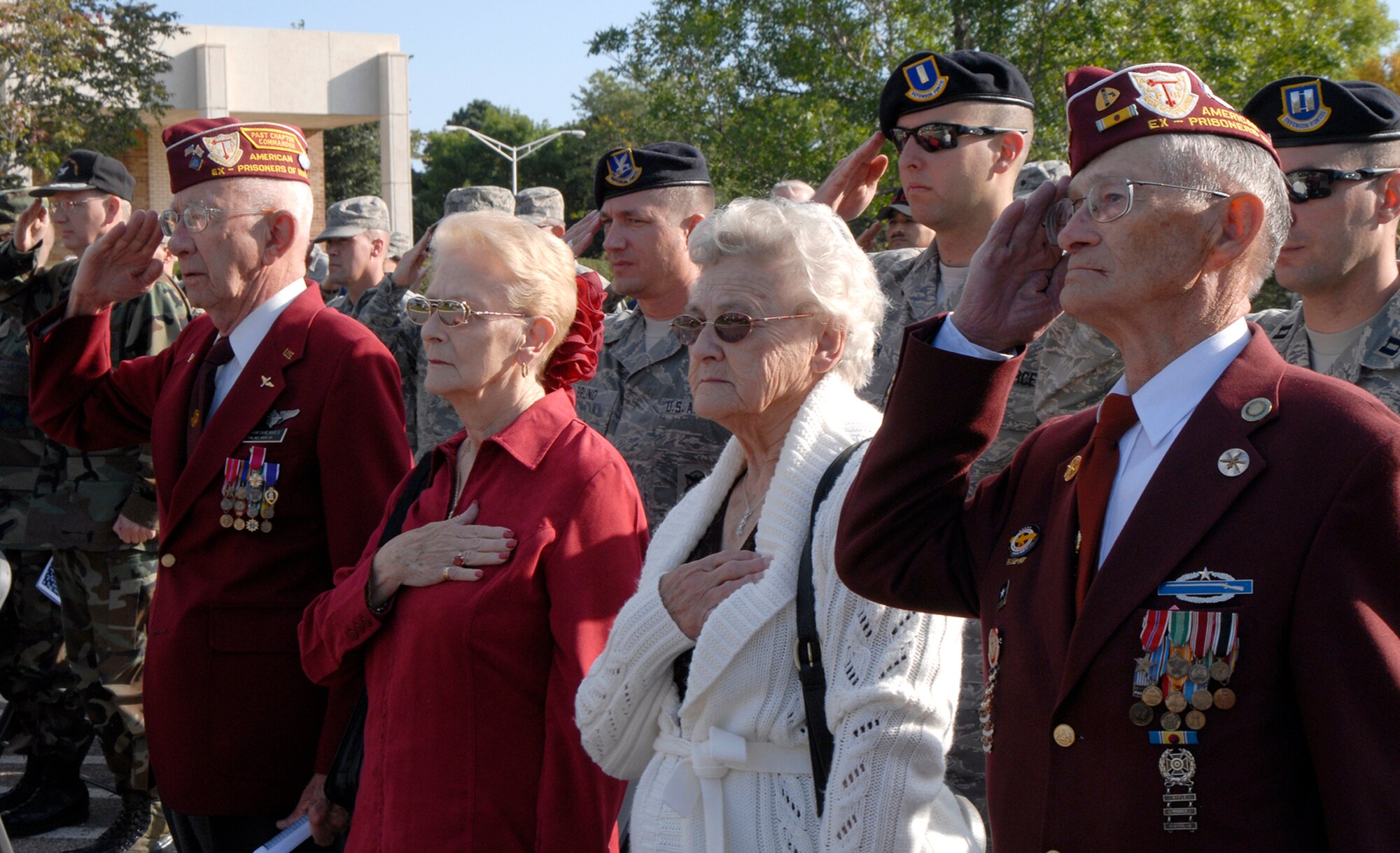 Former POWs and guests pay respect to the American flag during the singing of the National Anthem Sept. 19 at the POW/MIA Remembrance Ceremony held at the Peterson Air Force Base chapel in Colorado. The event was used as a forum to inform personnel about POW/MIA Remembrance Week on the base, which ran Sept. 15-19. POW/MIA week allowed members of the installation to remember those held prisoner of war and those missing in action during times of conflict. (U.S. Air Force photo/Craig Denton)