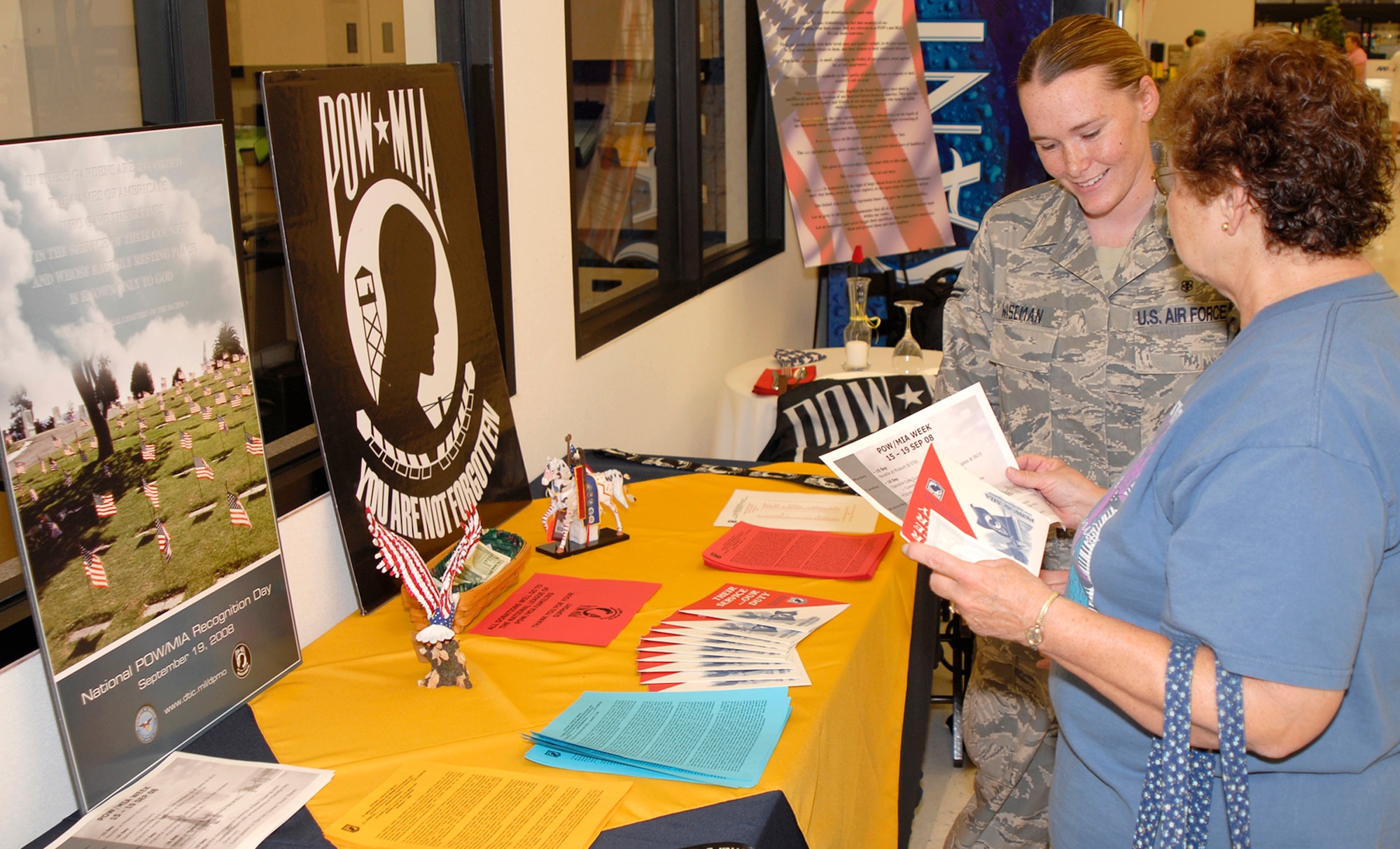 Airman 1st Class Ladonna Wiseman, 21st Dental Squadron, gives literature to Colorado Springs rsident Carole Klock from the POW/MIA information table Sept. 17 at the Peterson Air Force Base exchange. The event was used as a forum to inform personnel about POW/MIA Remembrance Week on the base, which ran Sept. 15-19. POW/MIA week allowed members of the installation to remember those held prisoner of war and those missing in action during times of conflict. (U.S. Air Force photo/Craig Denton)