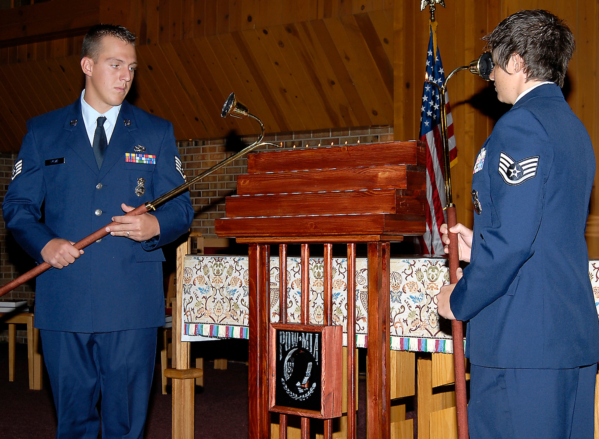 Staff Sgts. Joe Lyszaz (left) and Melinda Miller light candles as POW/MIA names are read aloud to a crowd Sept. 16 at the Peterson Air Force Base chapel in Colorado. The candle-light vigil allowed members of the installation to remember those held prisoner of war and those missing in action during times of conflict. (U.S. Air Force photo/Roberta McDonald)