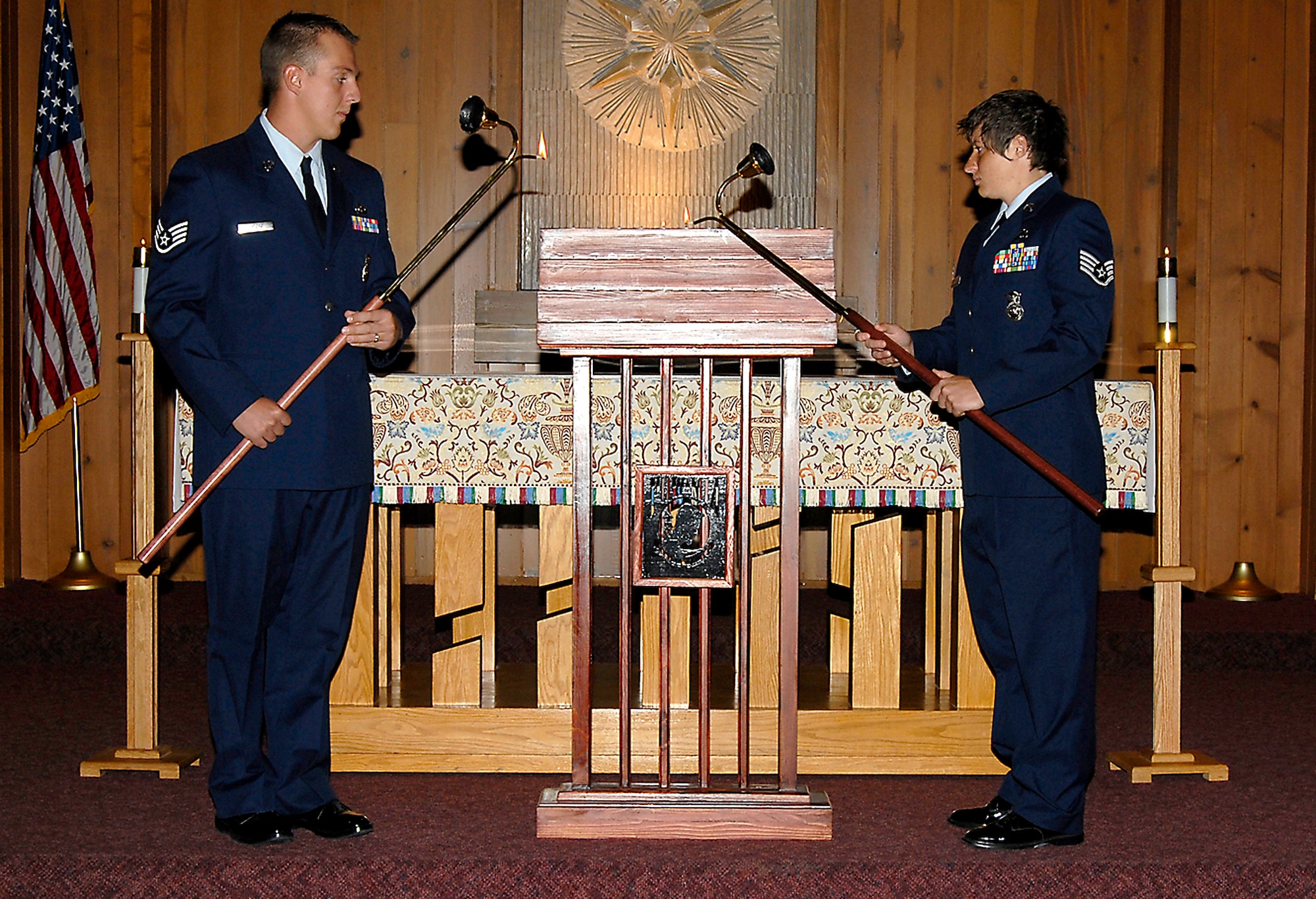 Staff Sgts. Joe Lyszaz (left) and Melinda Miller light candles as POW/MIA names are read aloud to a crowd Sept. 16 at the Peterson Air Force Base chapel in Colorado. The candle-light vigil allowed members of the installation to remember those held prisoner of war and those missing in action during times of conflict. (U.S. Air Force photo/Roberta McDonald)