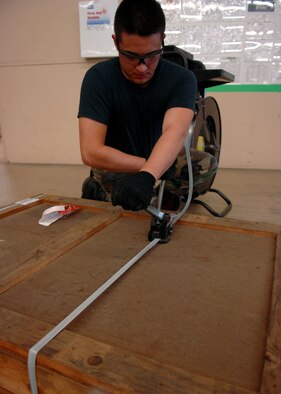 MOODY AIR FORCE BASE, Ga. – Airman 1st Class David Ivester, 23rd Logistics Readiness Squadron traffic management office apprentice, tightens a nylon string here Sept. 15., Airman Ivester seals the crate with three nylon strings.  (U.S. Air Force photo by Airman Joshua Green)  