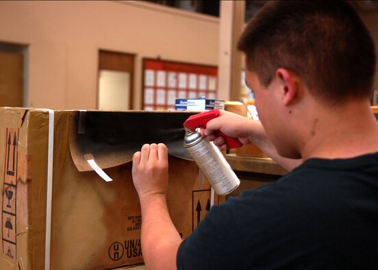 MOODY AIR FORCE BASE, Ga. – Airman 1st Class David Ivester, 23rd Logistics Readiness Squadron traffic management office apprentice, spray paints a stencil onto a packaged box here Sept. 15. Using spray paint and a stencil, Airman Ivester,  makes his work quick and easy. (U.S. Air Force photo by Airman Joshua Green)  